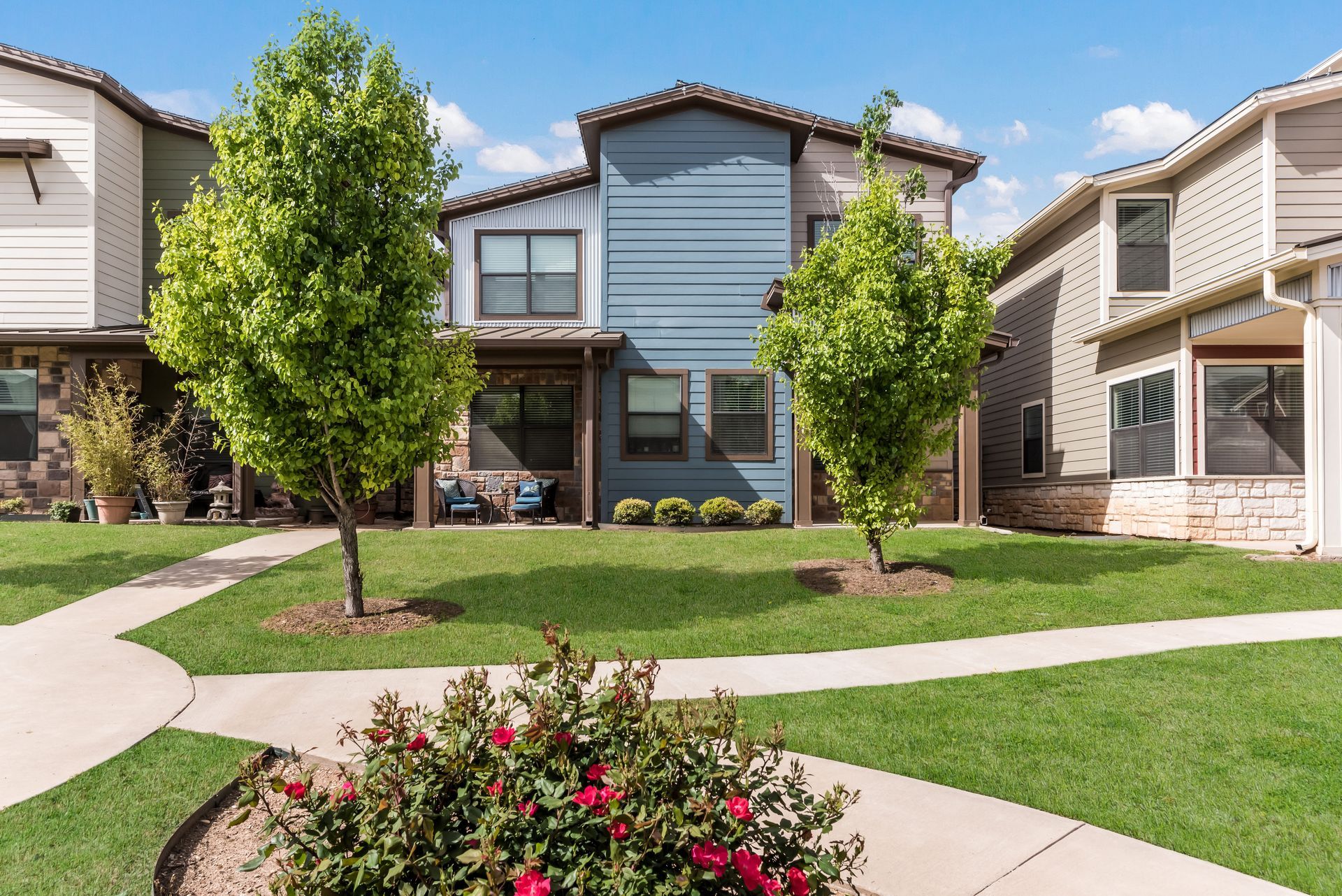 A row of houses are sitting next to each other on a lush green lawn.