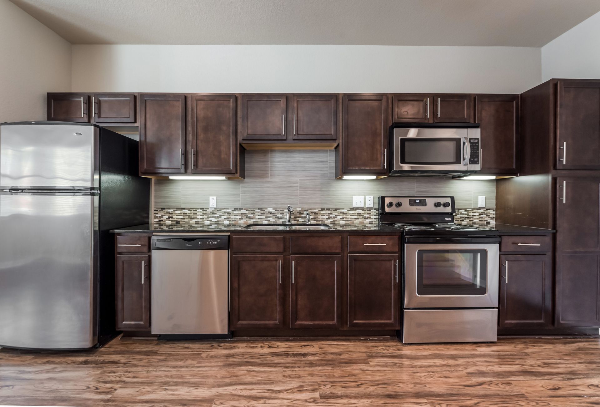 A kitchen with stainless steel appliances and wooden cabinets