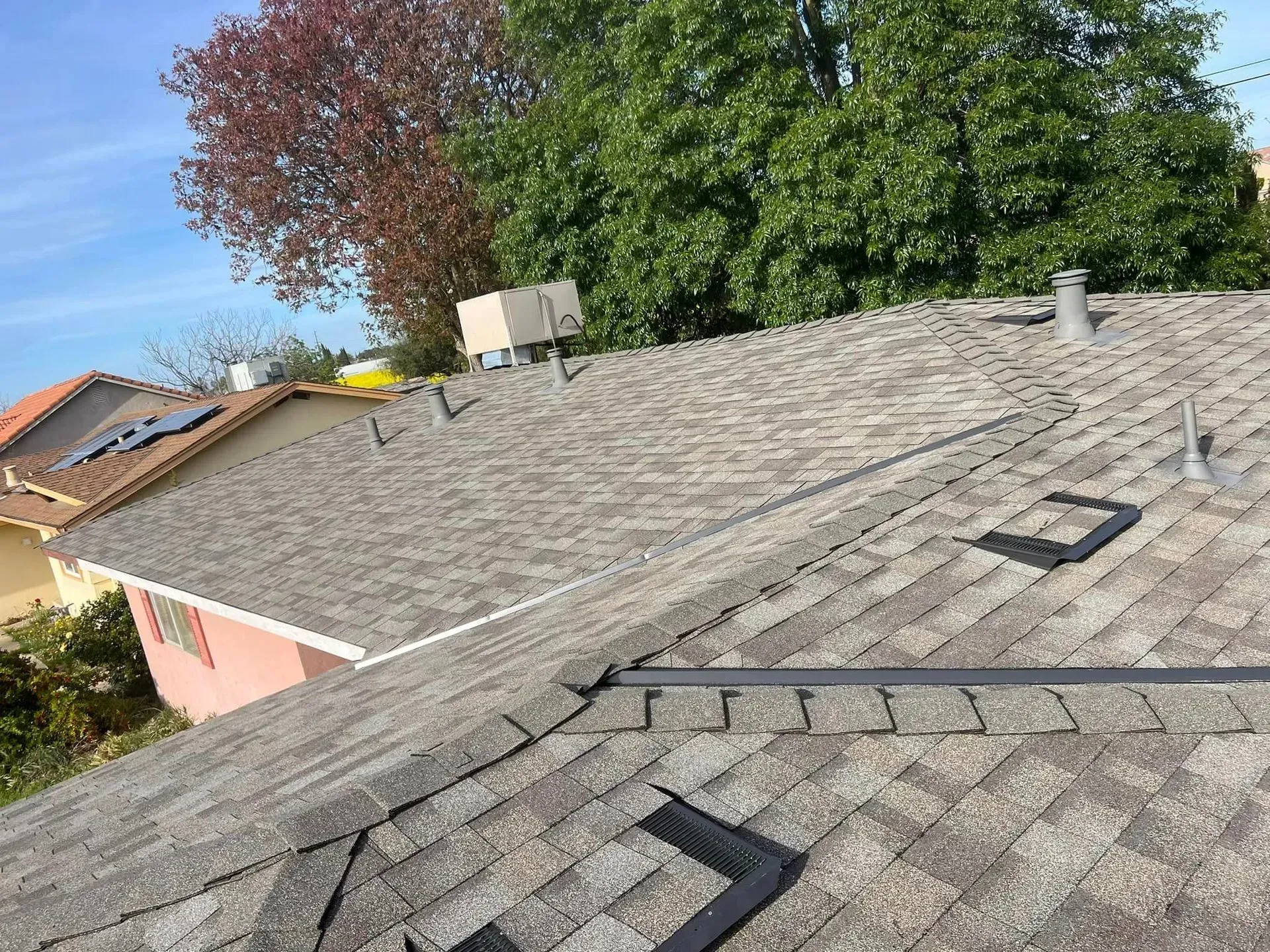 A close up of a roof with a few trees in the background.