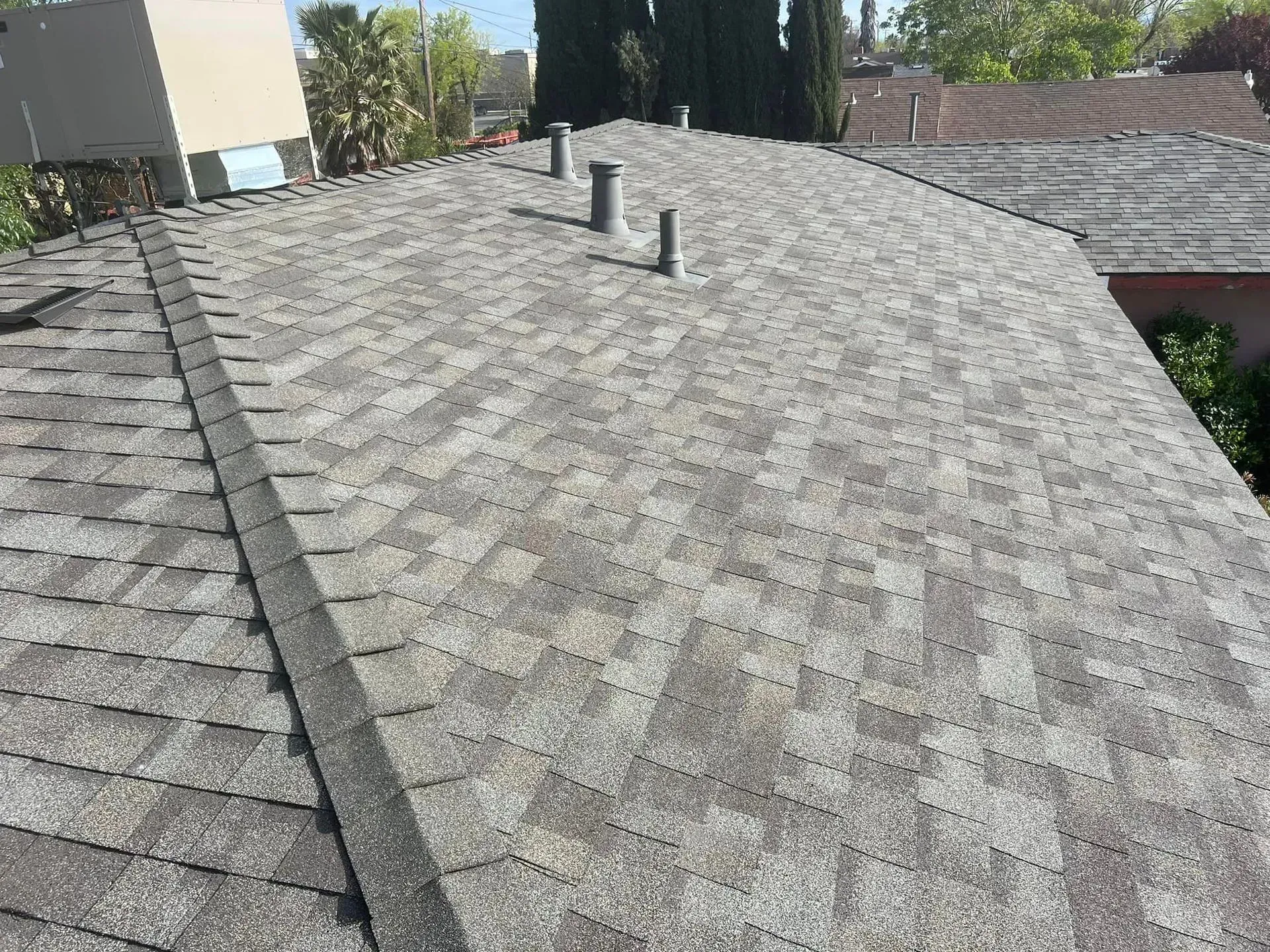 The roof of a house with a gray shingle roof.