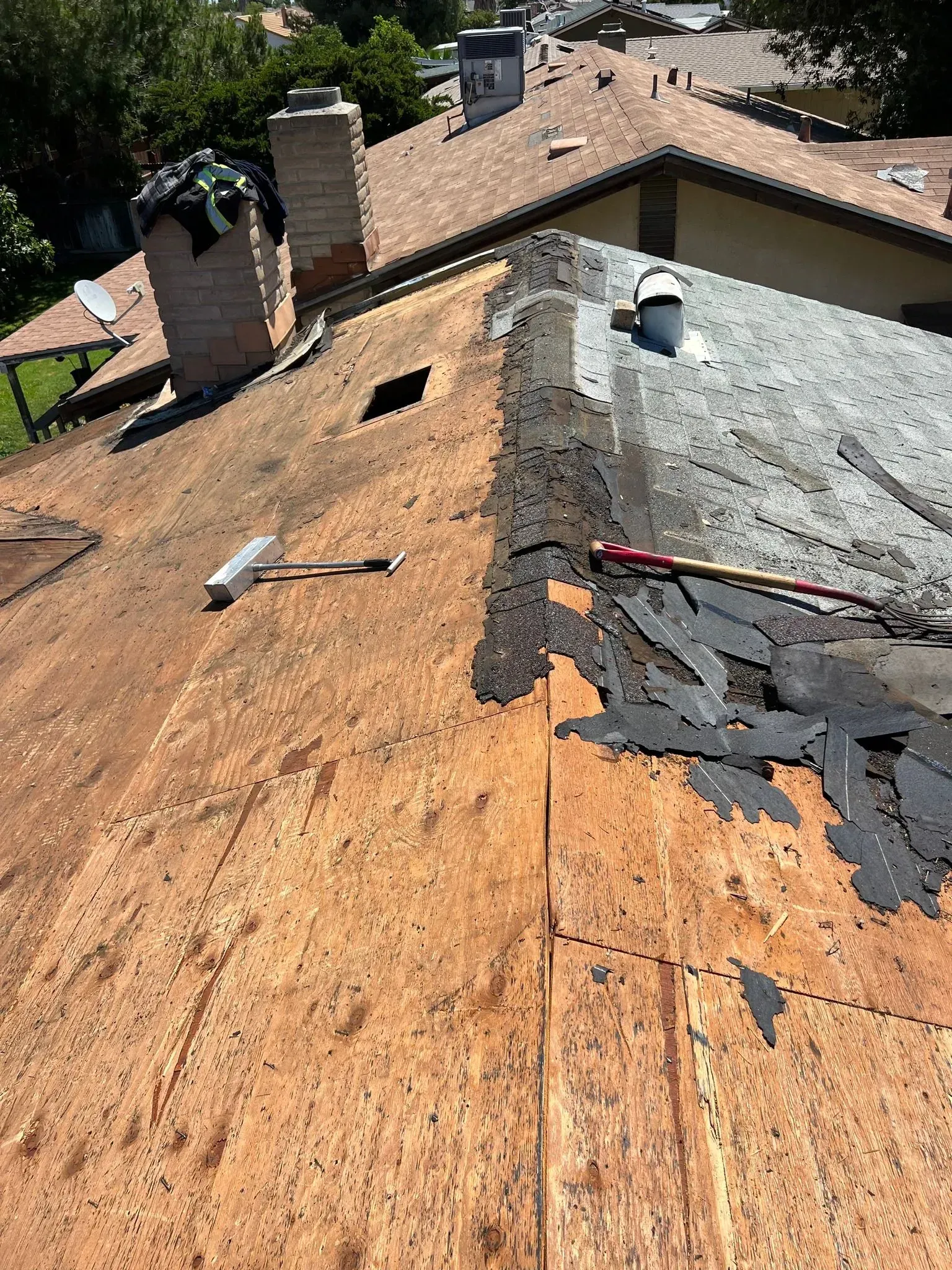 The roof of a house is being repaired with a hammer.