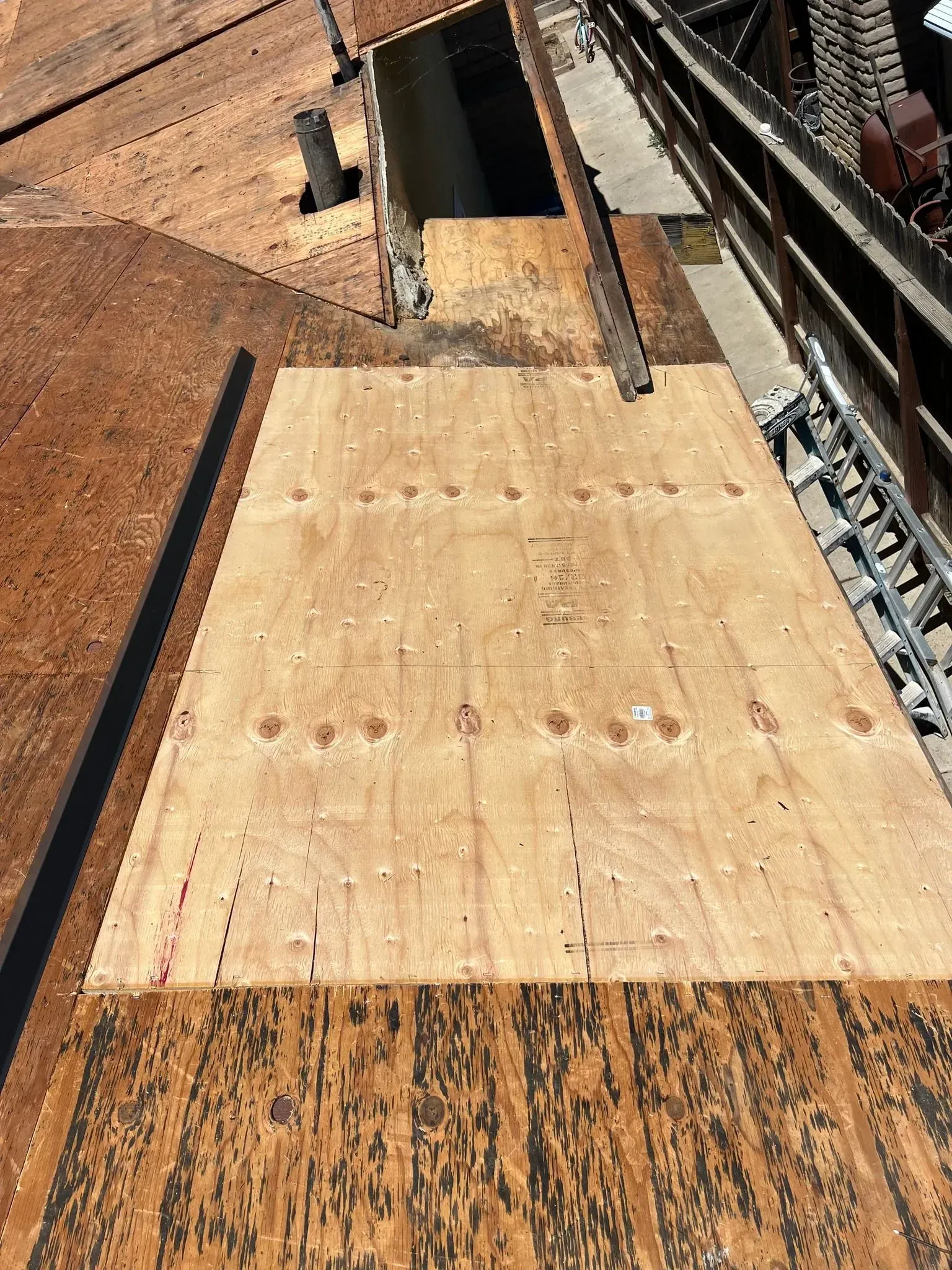 A large piece of wood is sitting on top of a roof.