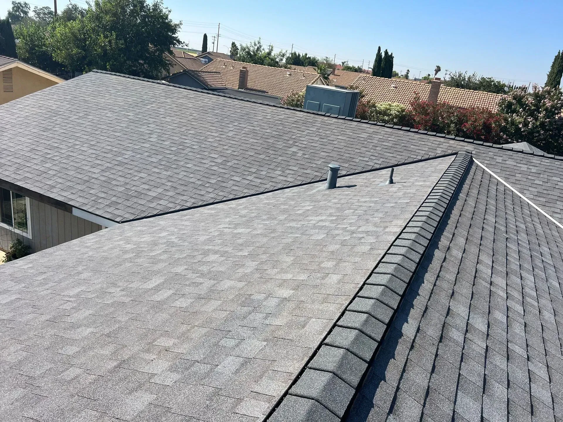 The roof of a house with a gray shingle roof