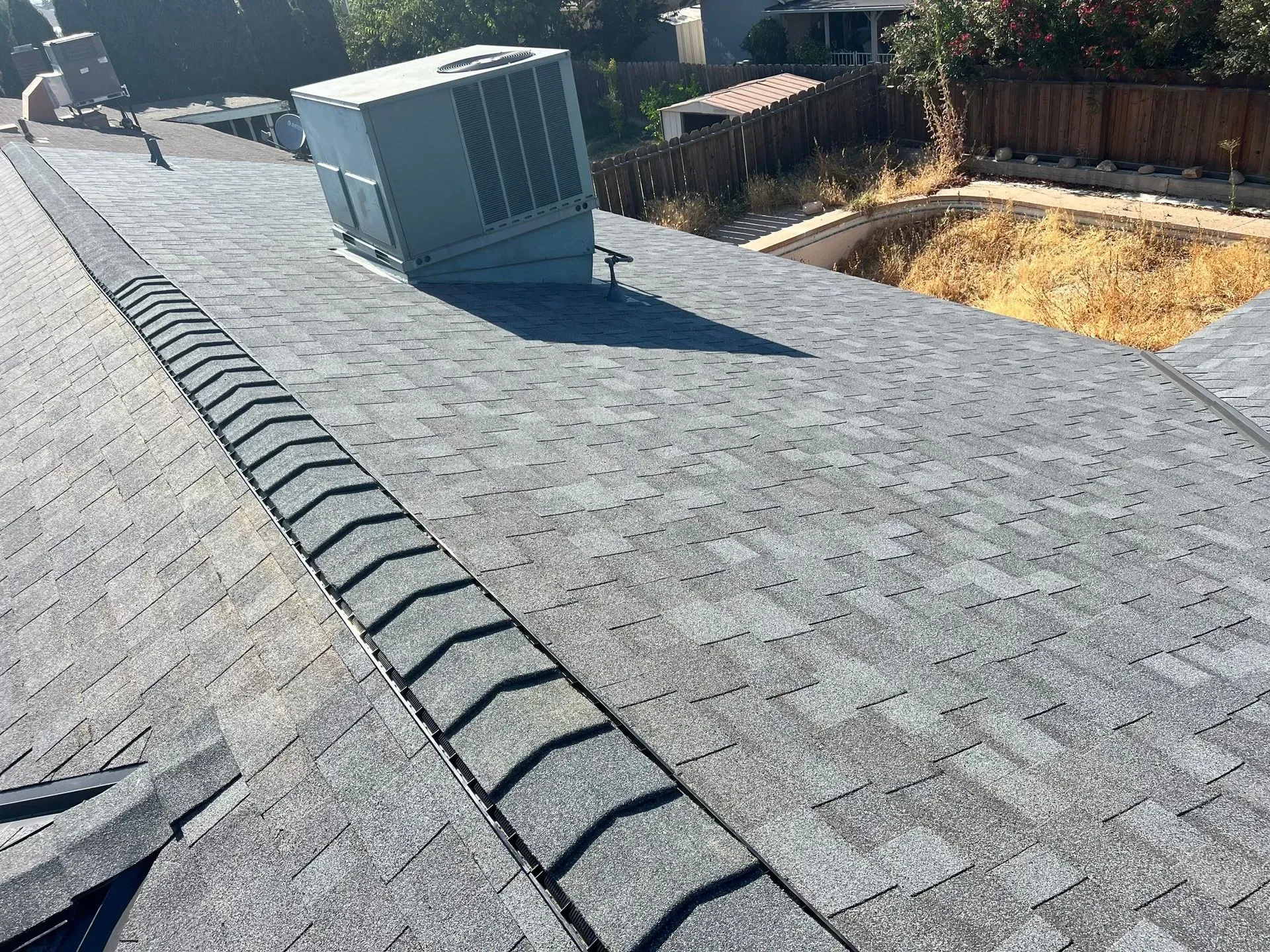 A roof with a drain and an air conditioner on it.