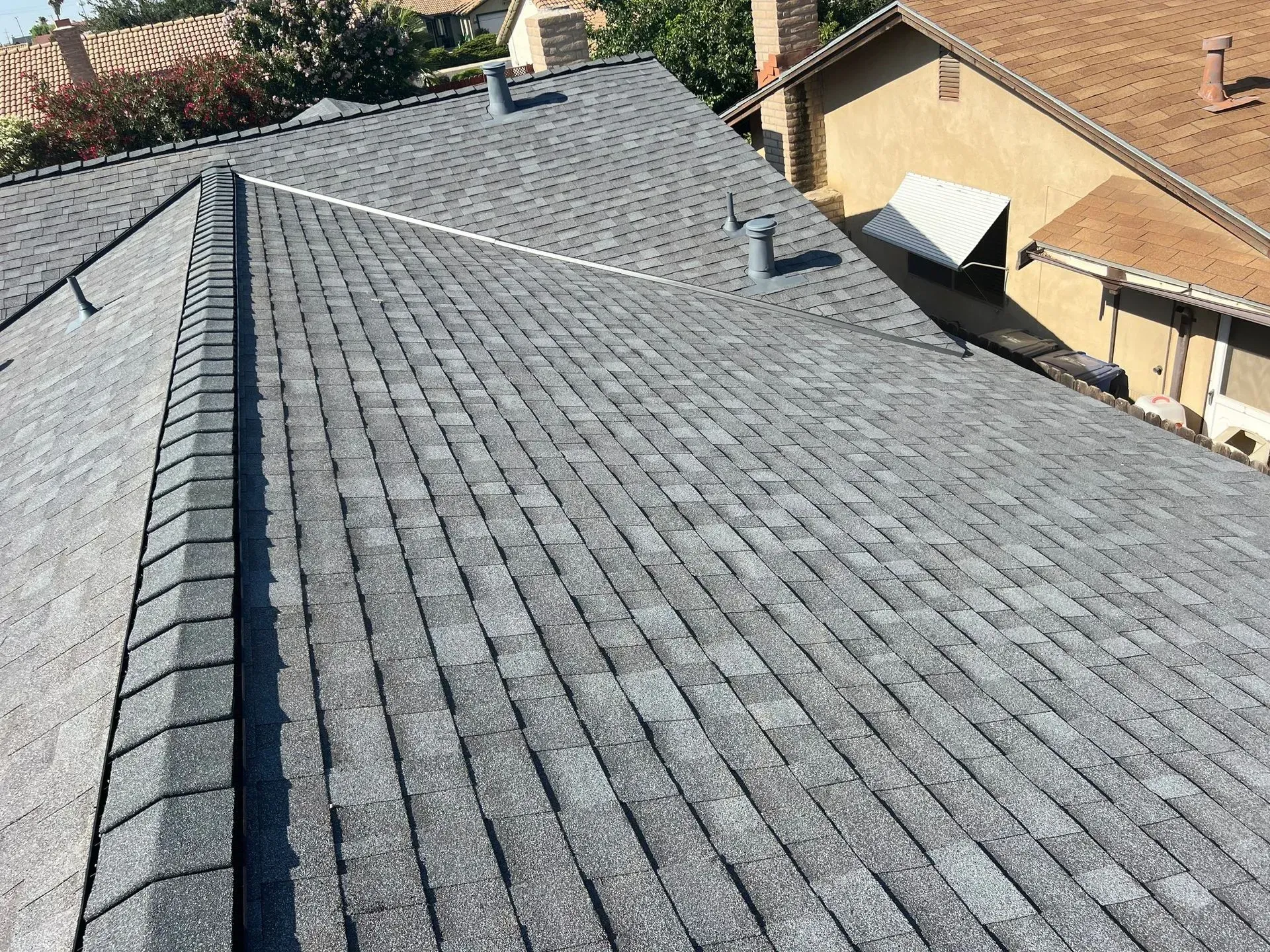 The roof of a house with a gray shingle roof.