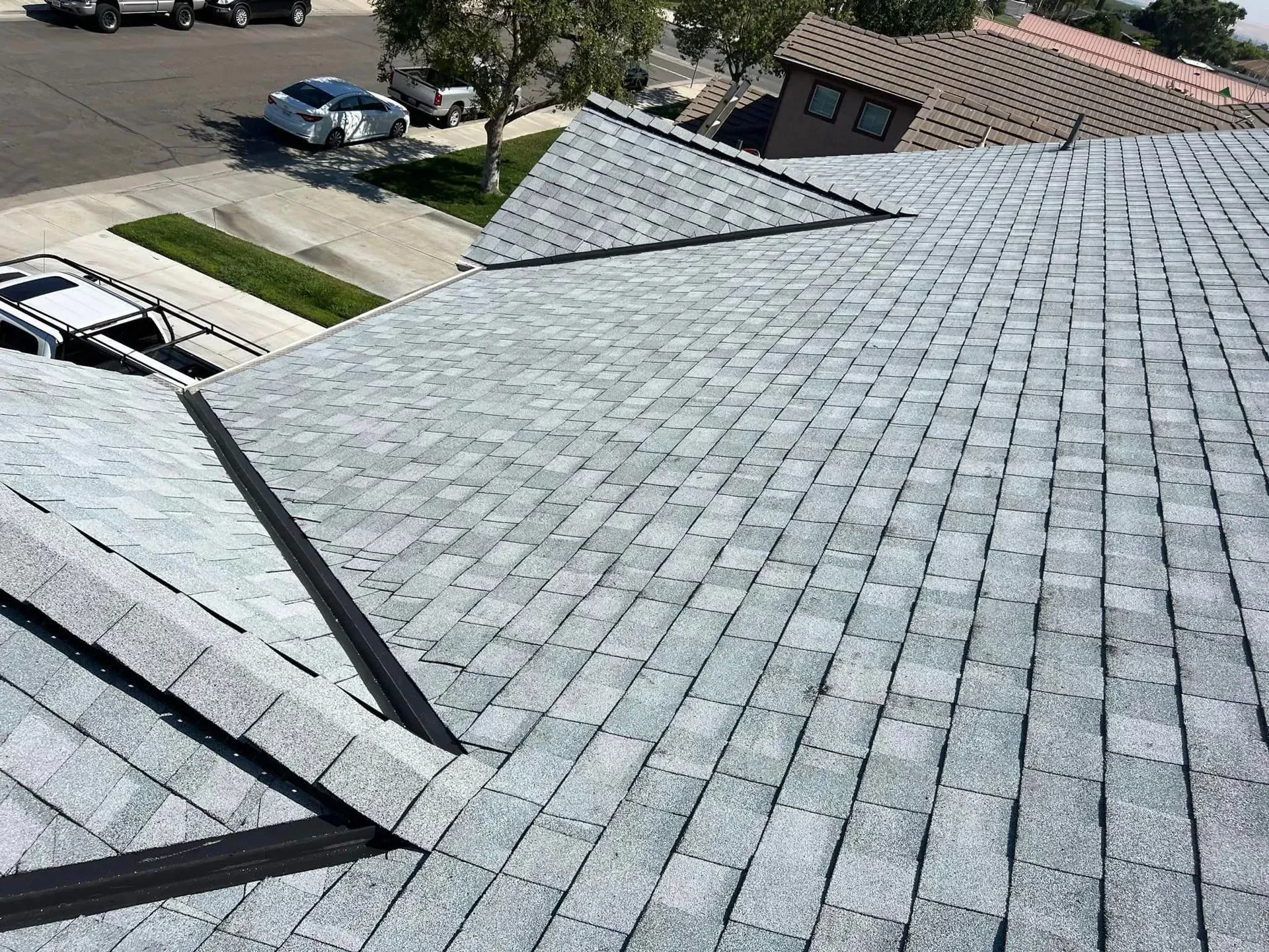 The roof of a house with a gray shingle roof.