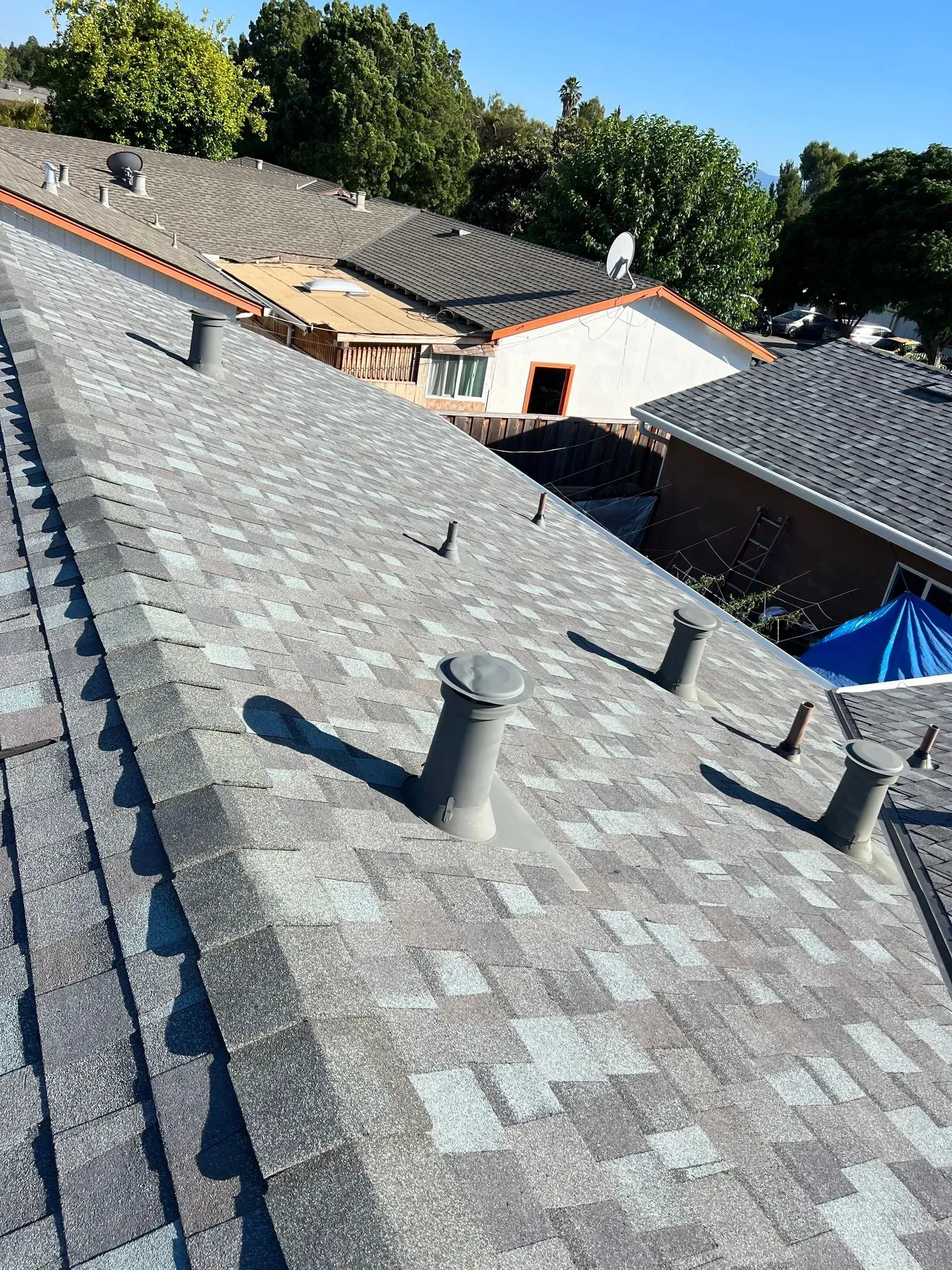 The roof of a house has a lot of vents on it.