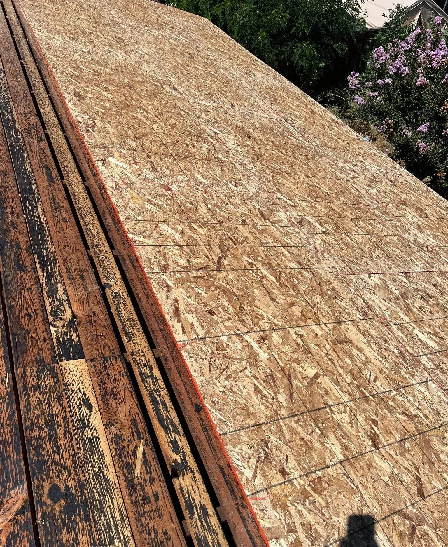 A roof made of plywood is sitting on top of a wooden deck.