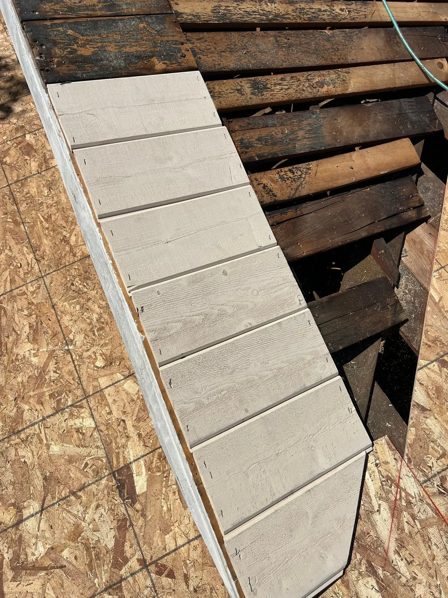 A piece of wood is sitting on top of a wooden deck.