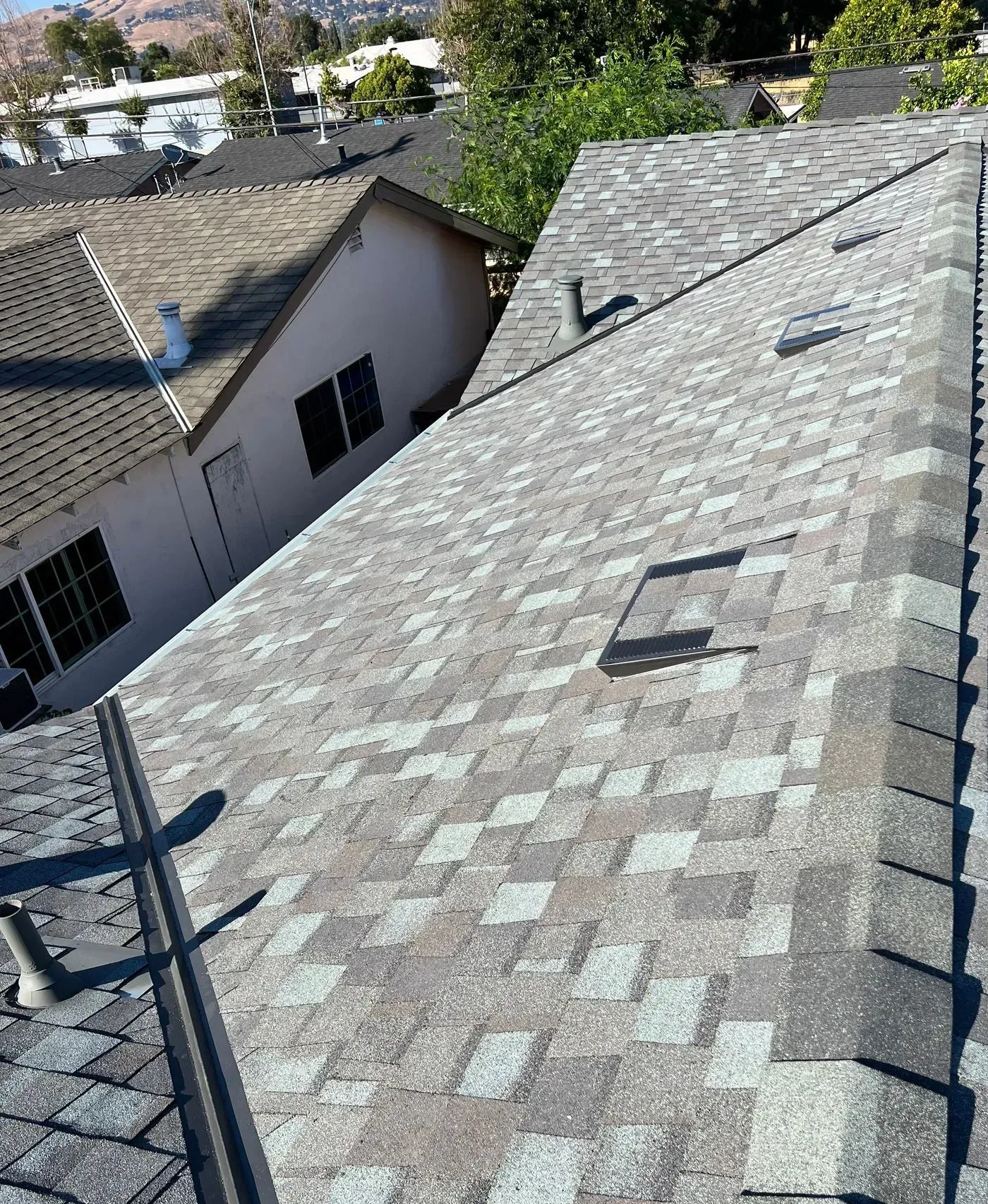 A close up of a roof with a few houses in the background.