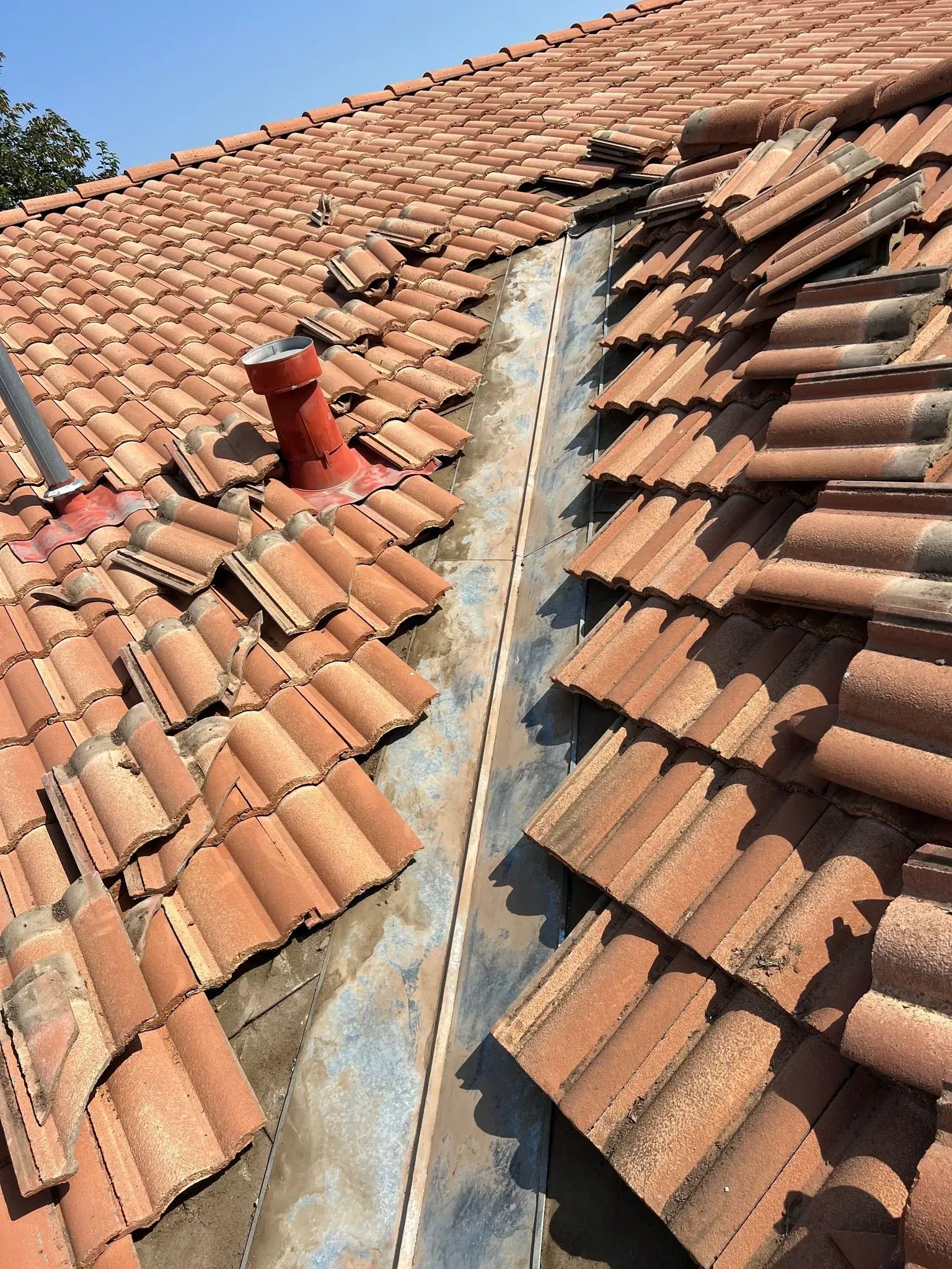 A roof with a lot of tiles and a chimney on it.