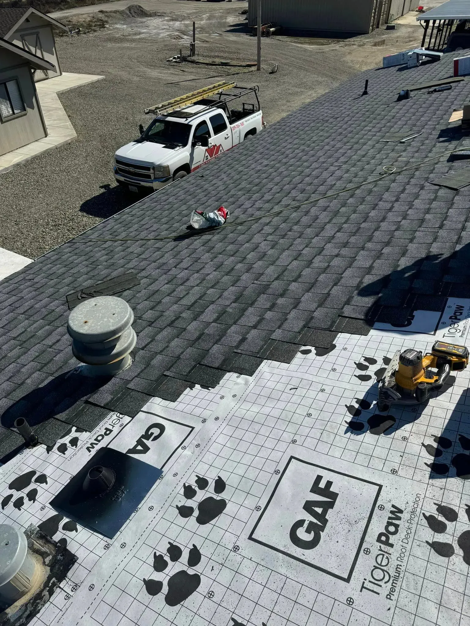 A white truck is parked on top of a roof.