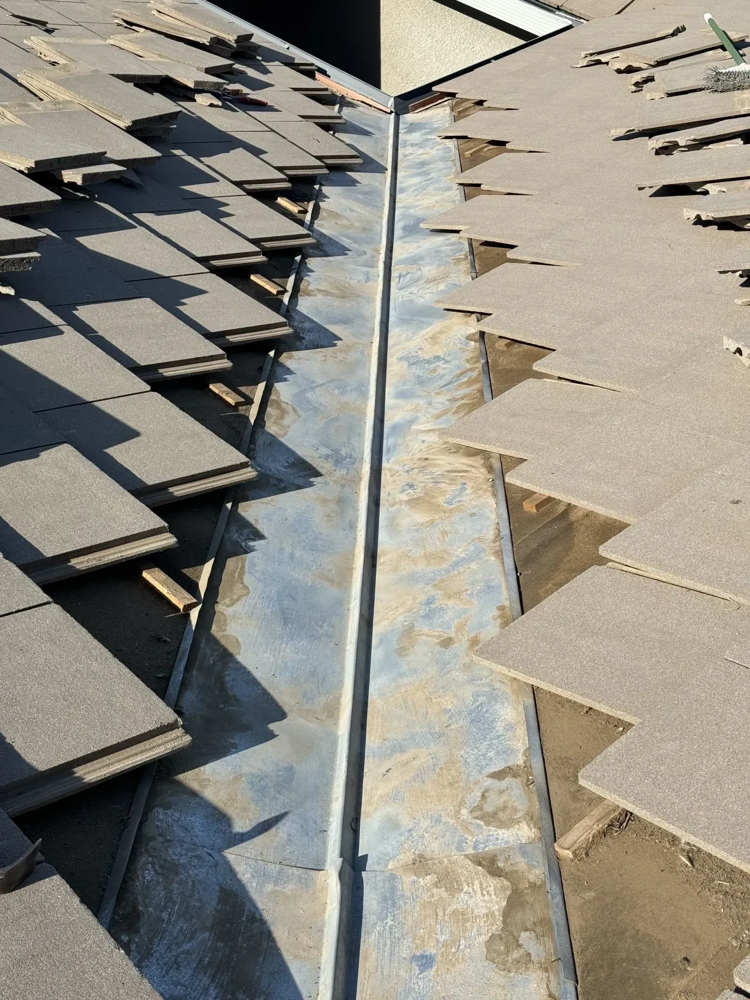 A close up of a roof with shingles being installed