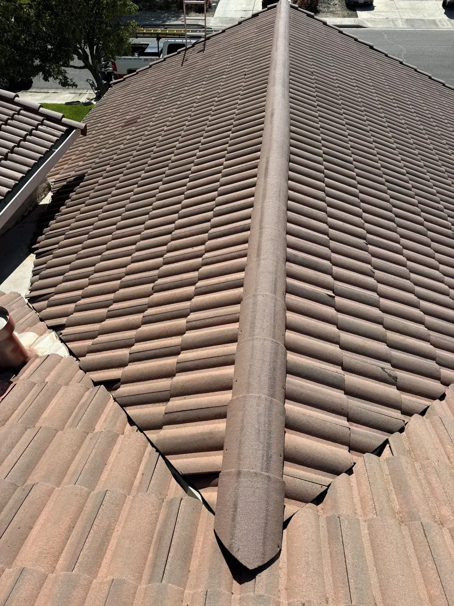 A close up of a tiled roof with a diagonal ridge.