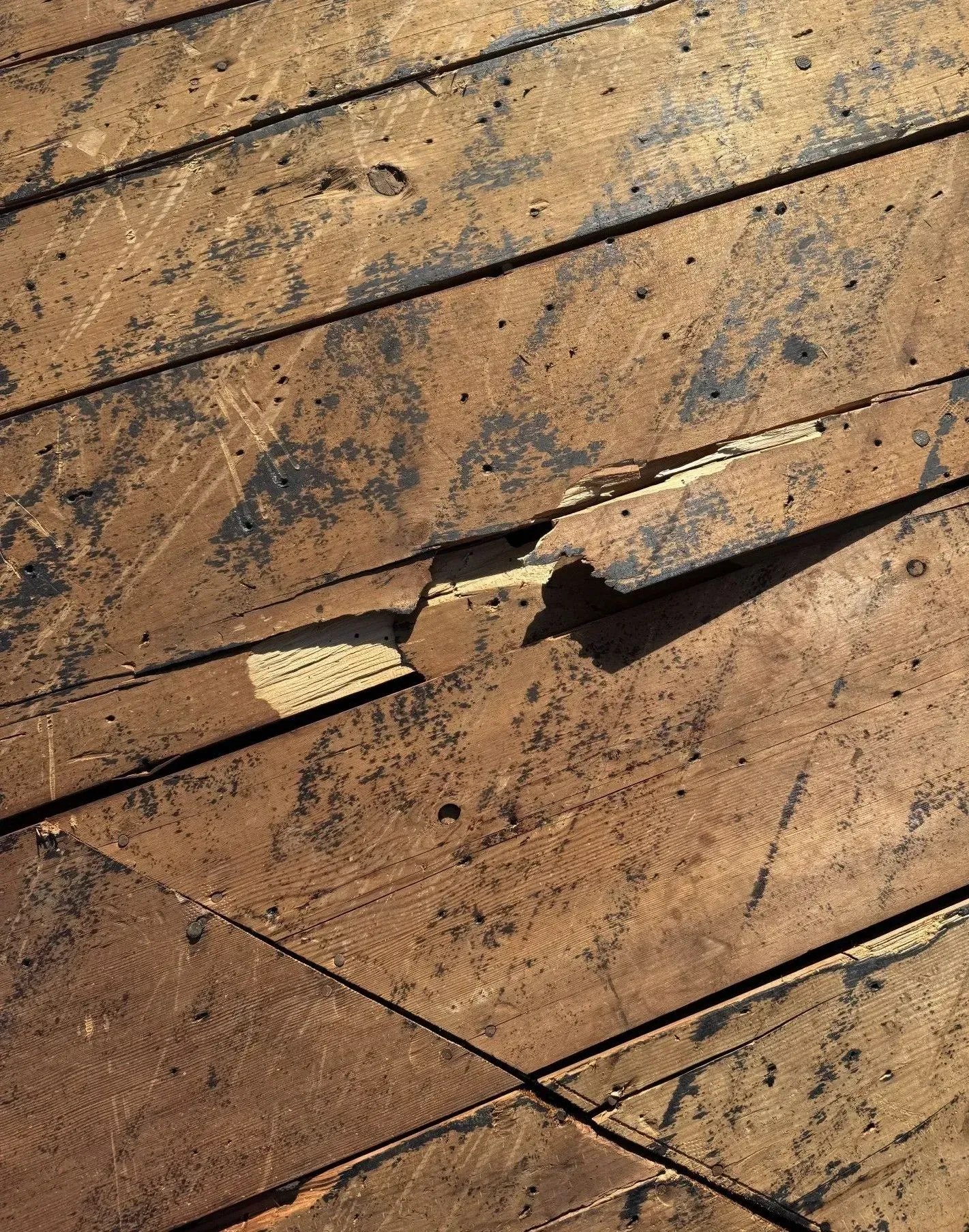 A close up of a wooden floor with a hole in it