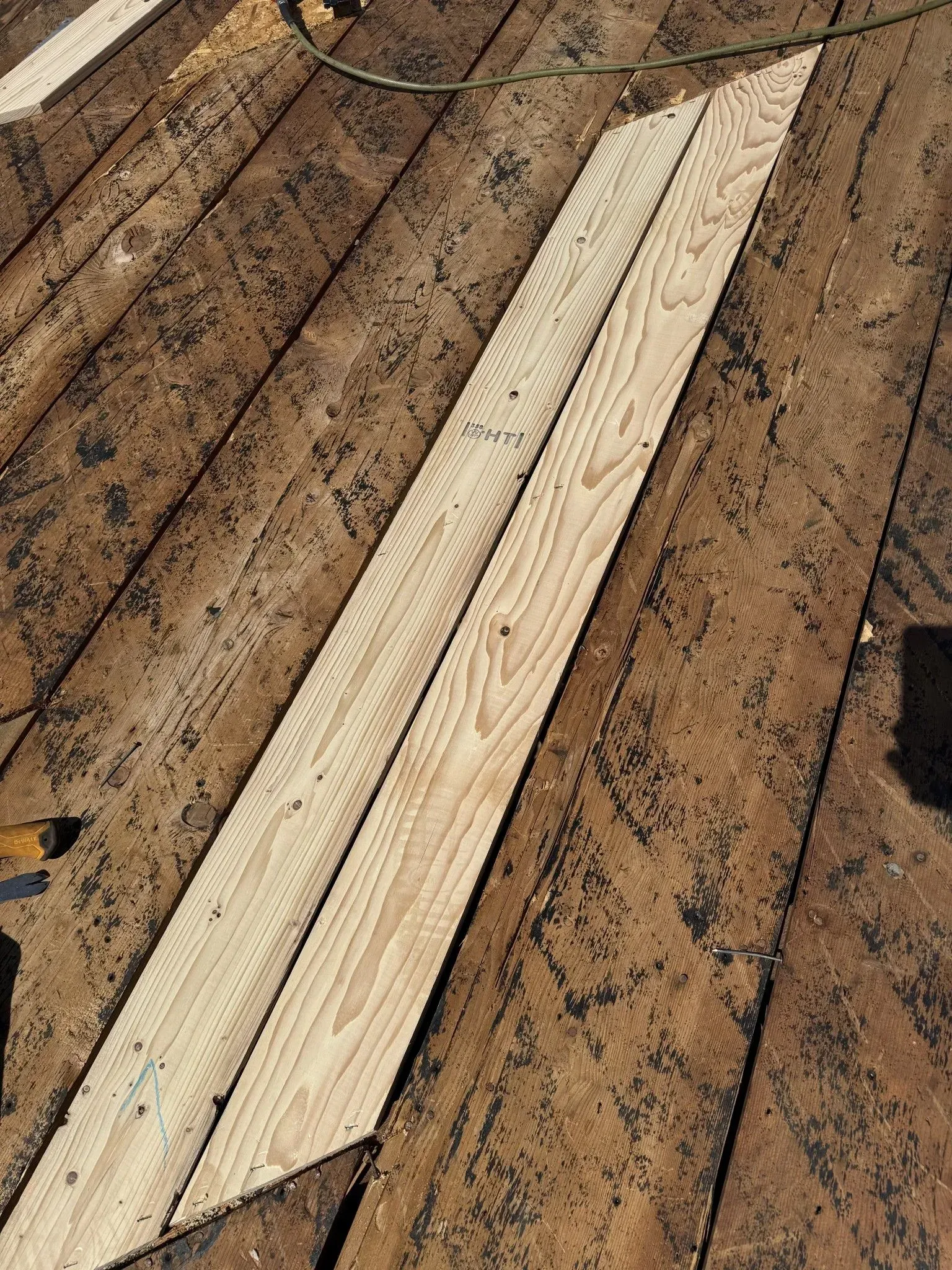 Two pieces of wood are sitting on top of a wooden deck.