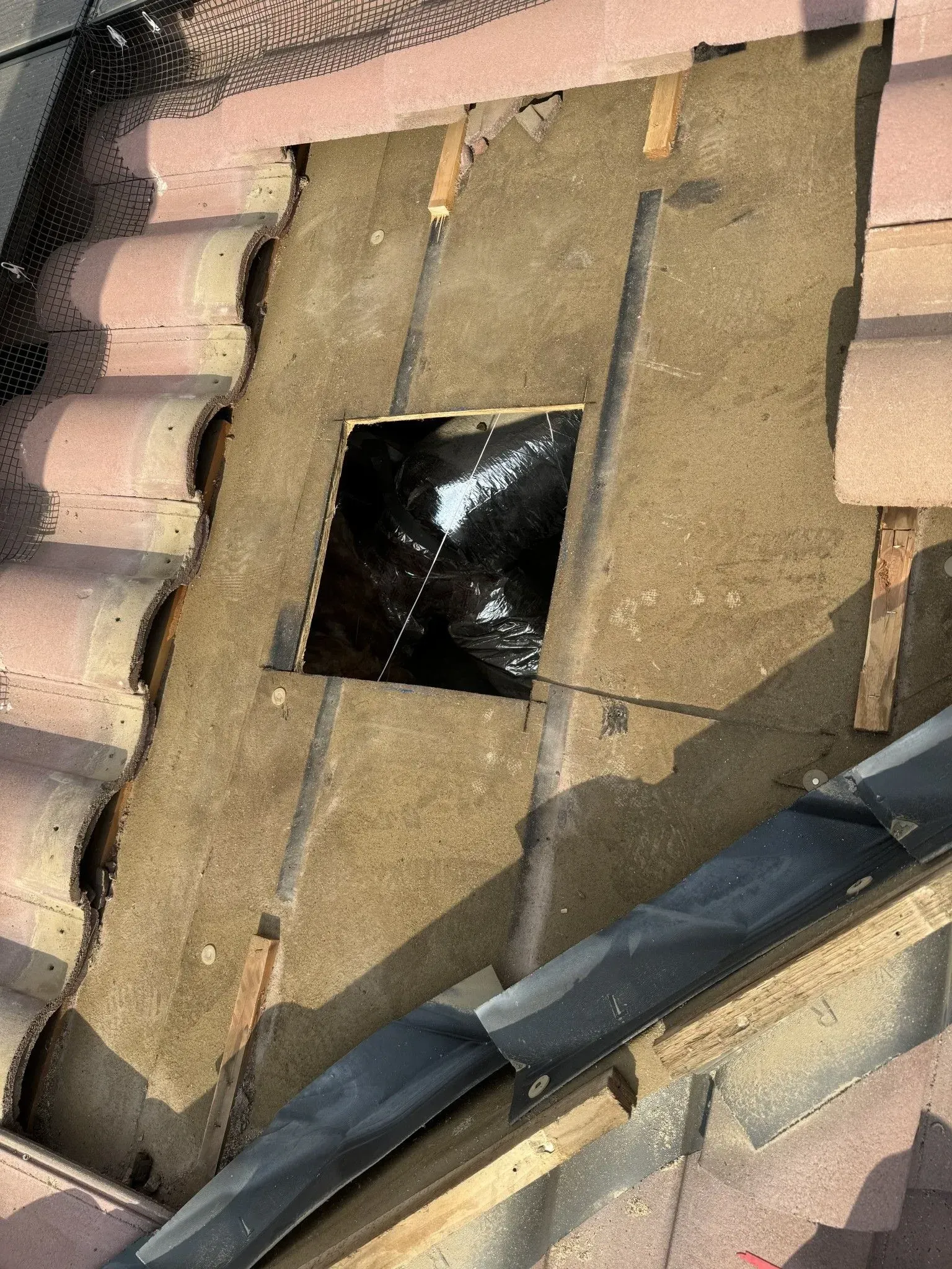 A roof with a hole in it that looks like a chimney.