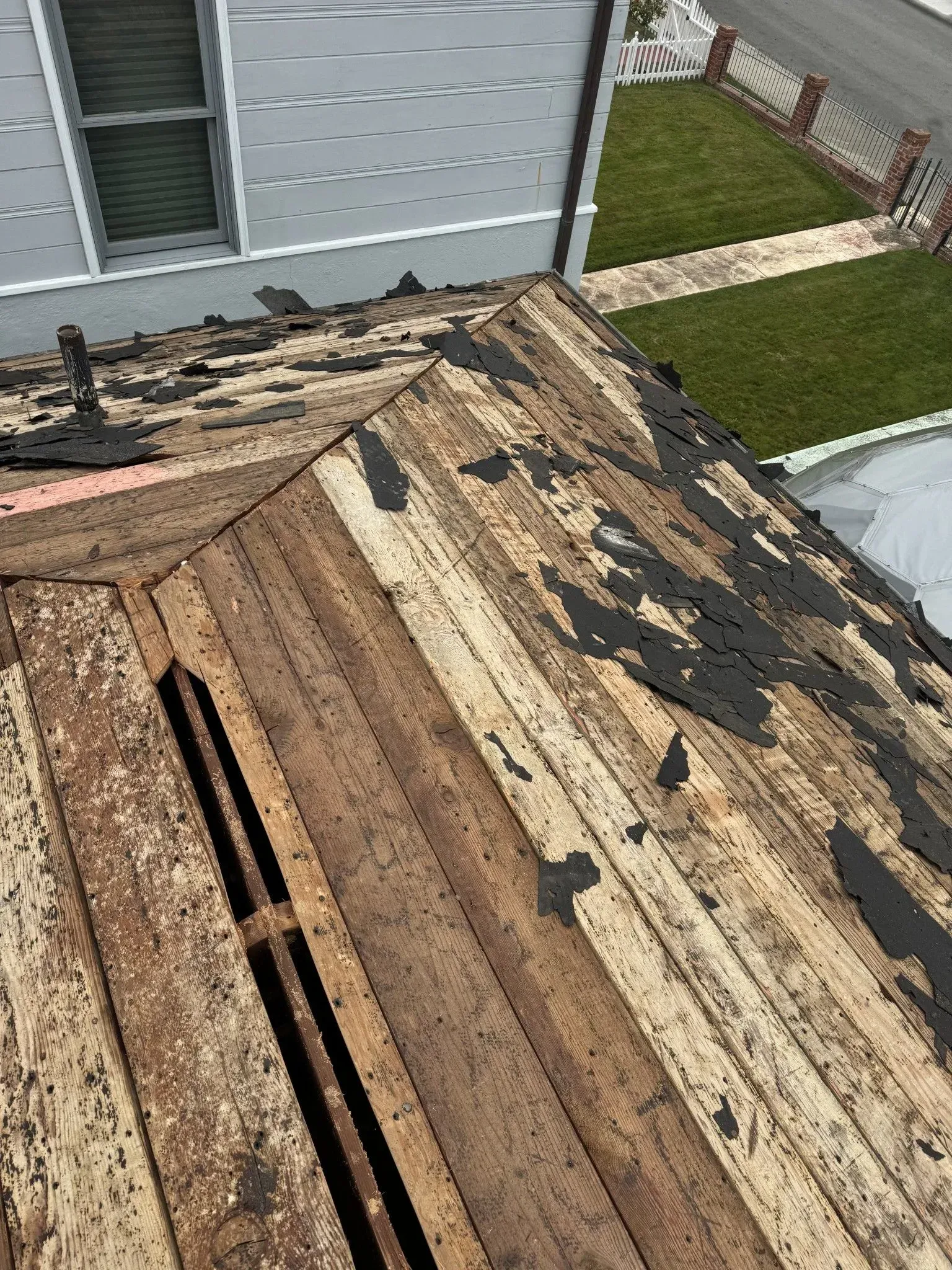 A wooden roof is being removed from a house.