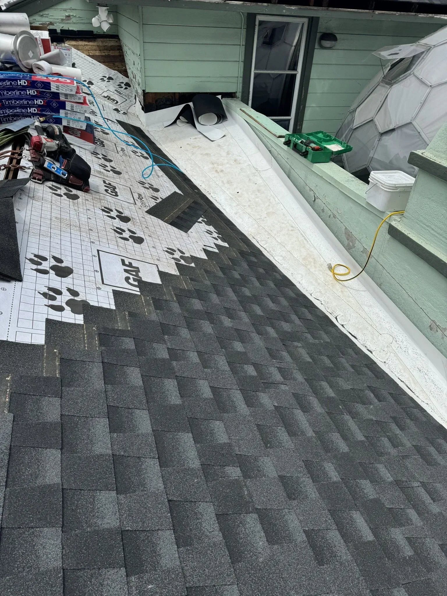A roof is being repaired on the side of a house.