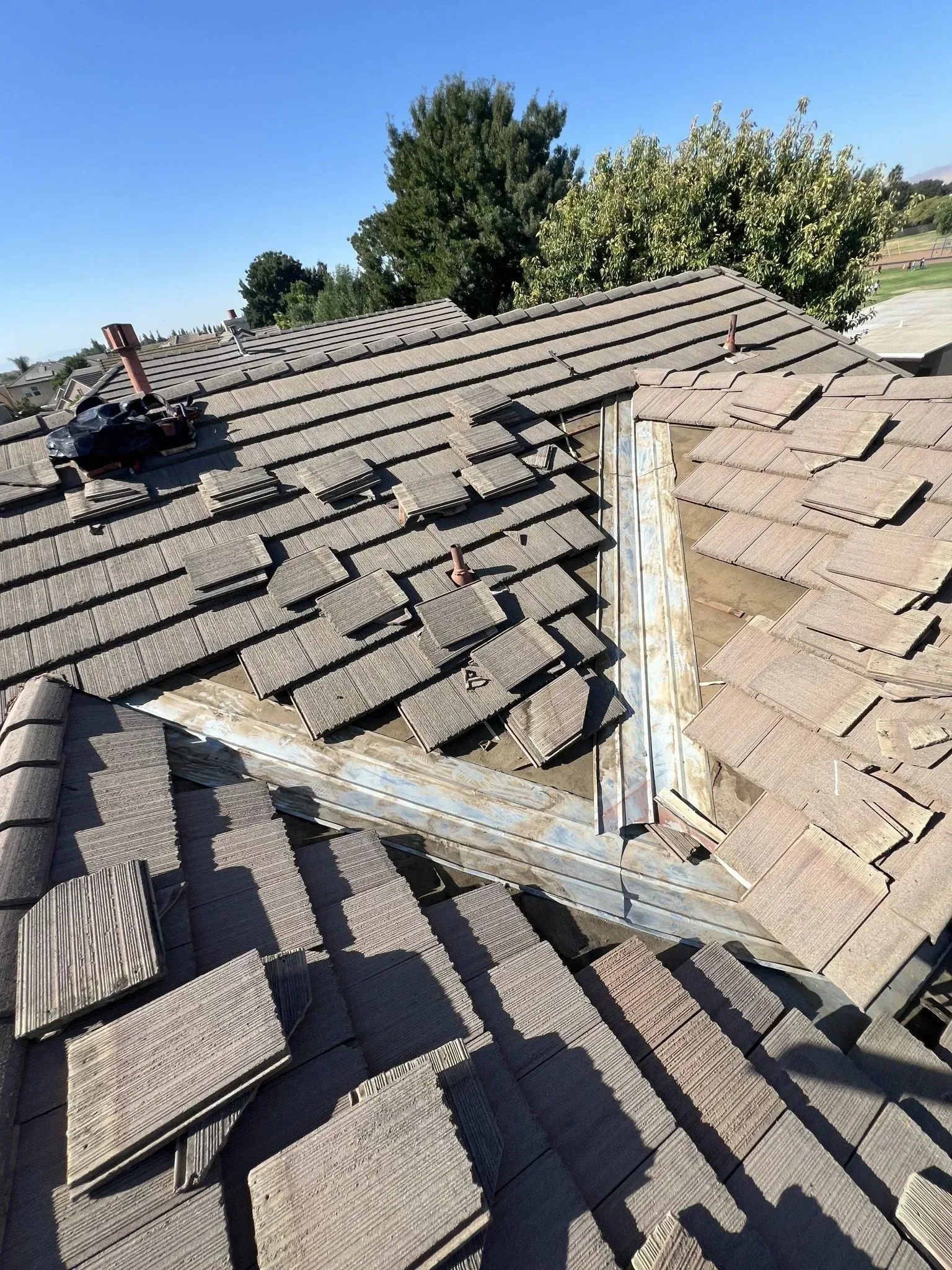 A roof with a lot of tiles on it and a chimney.