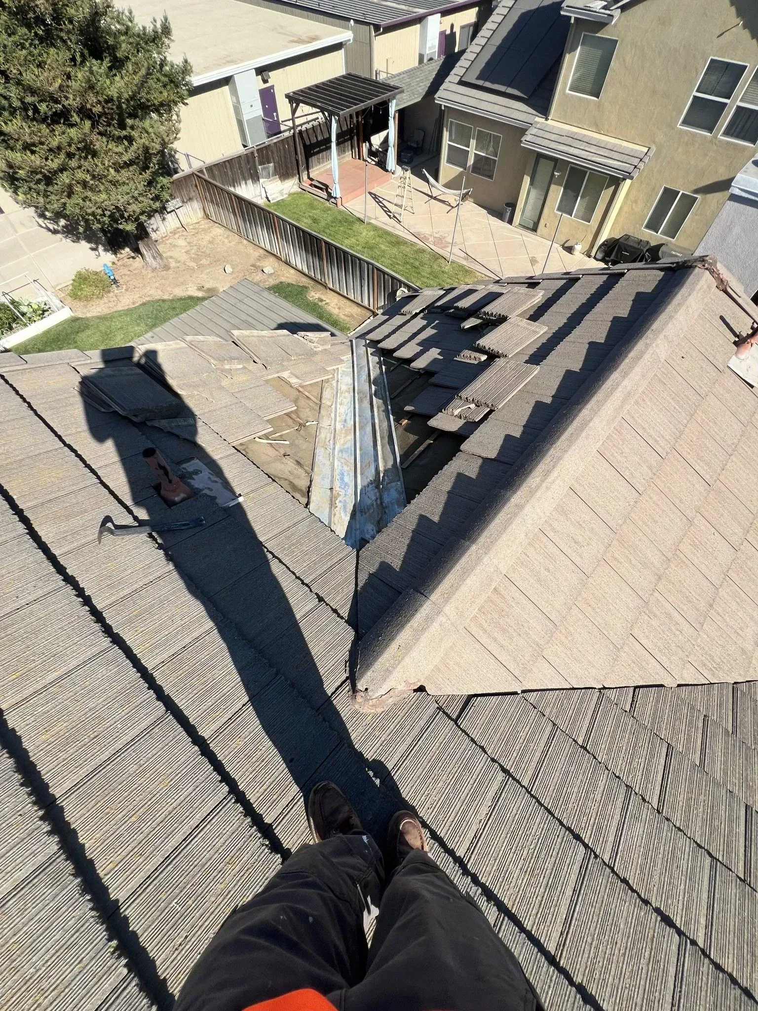 A person is standing on top of a roof looking down.