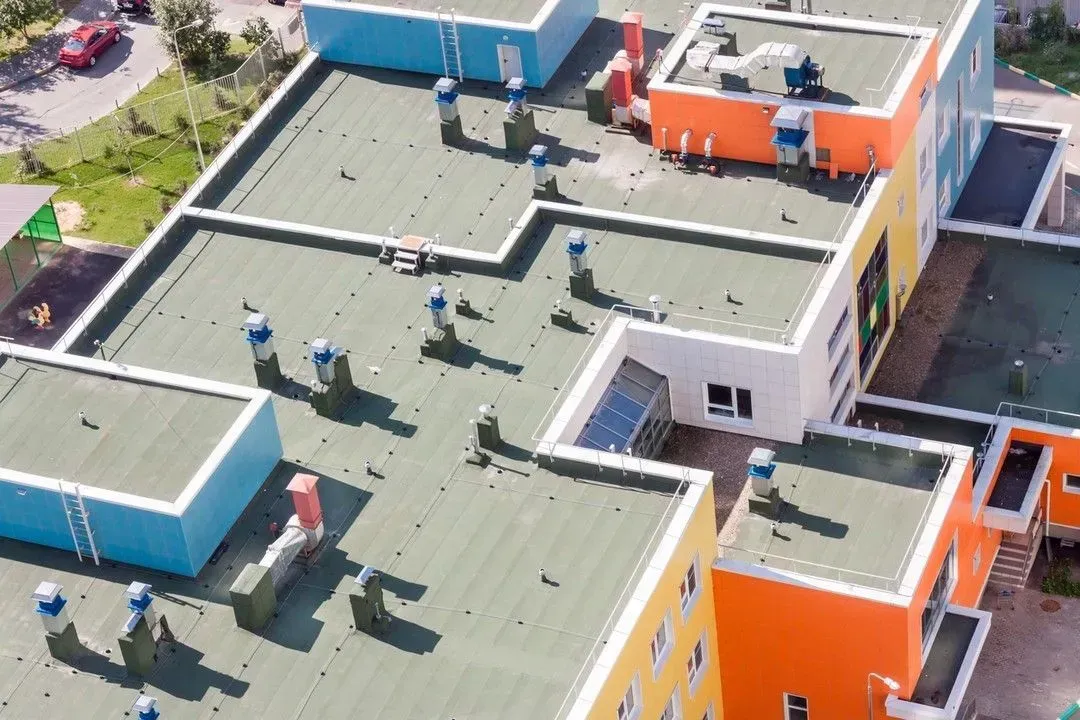 An aerial view of a colorful building with a green roof.