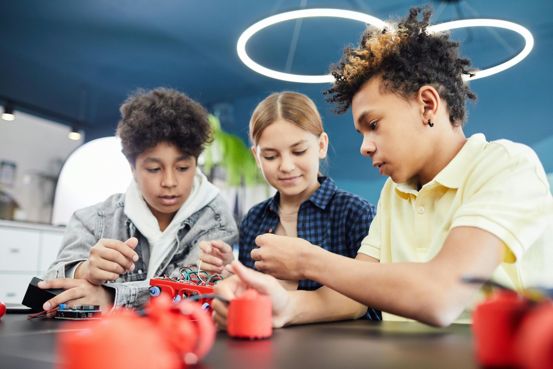 A group of children are sitting at a table playing with toys.