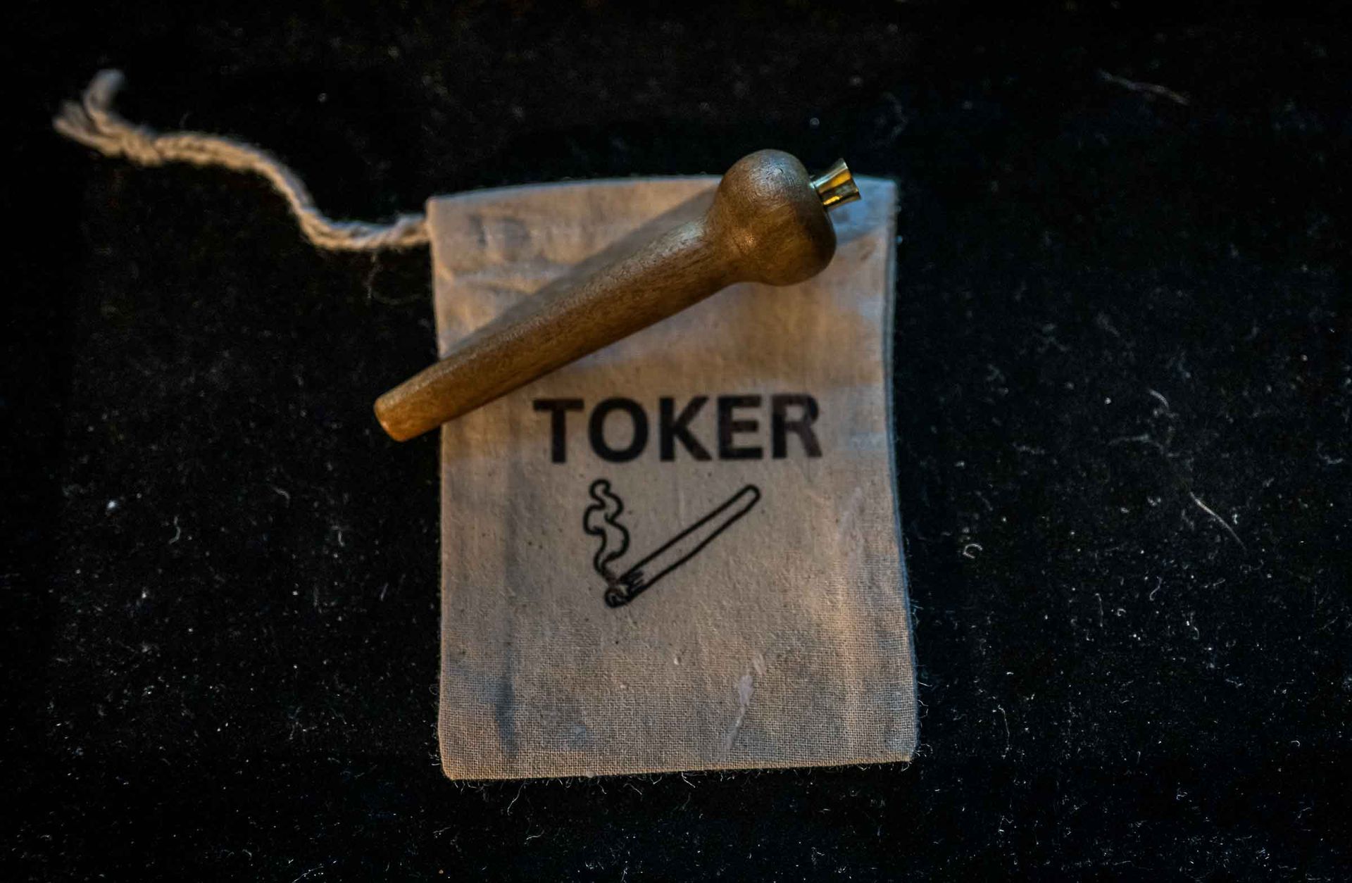 A small piece of wood is sitting on top of a toker bag.