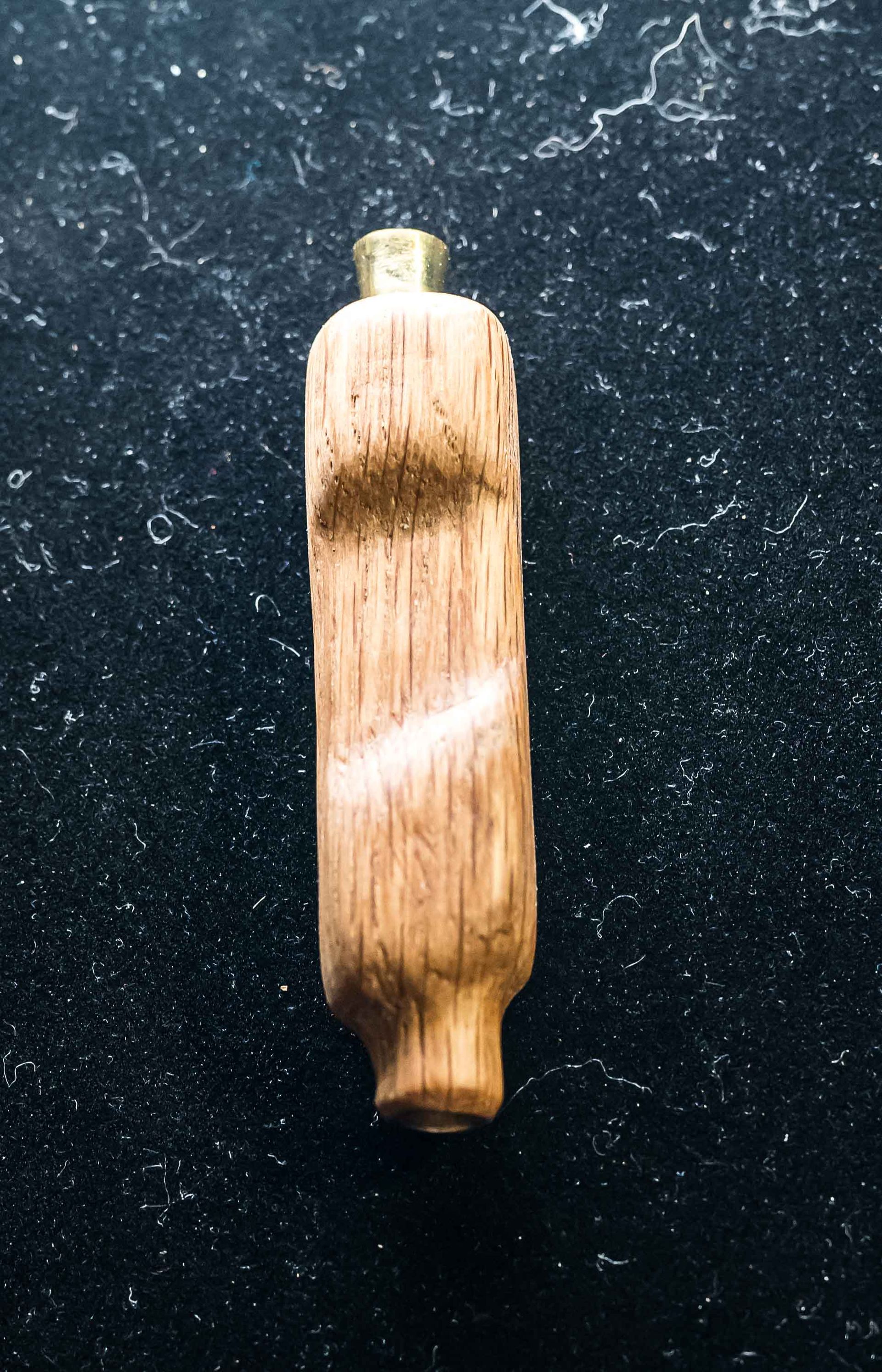 A wooden object is sitting on a black surface