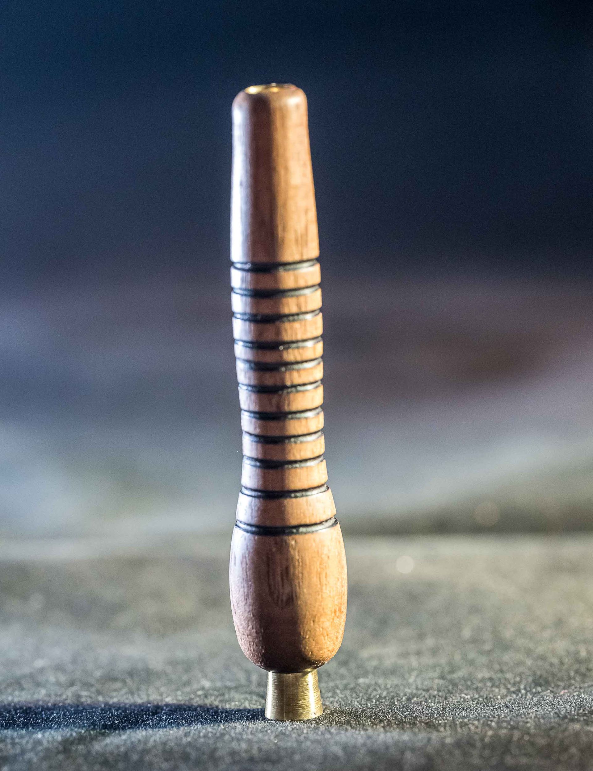 A small wooden stick is sitting on a table.