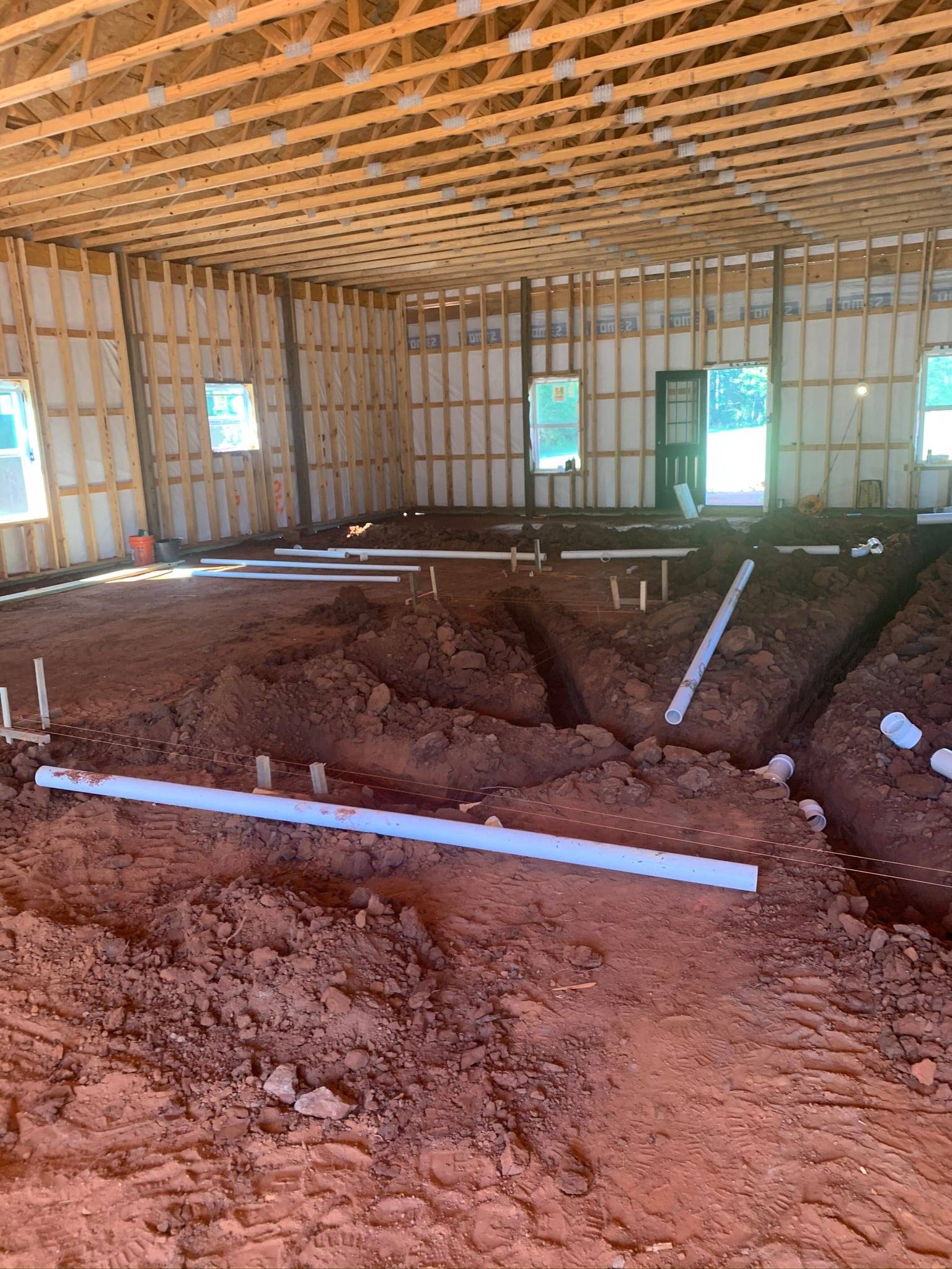 A large room with a lot of dirt and pipes in it.