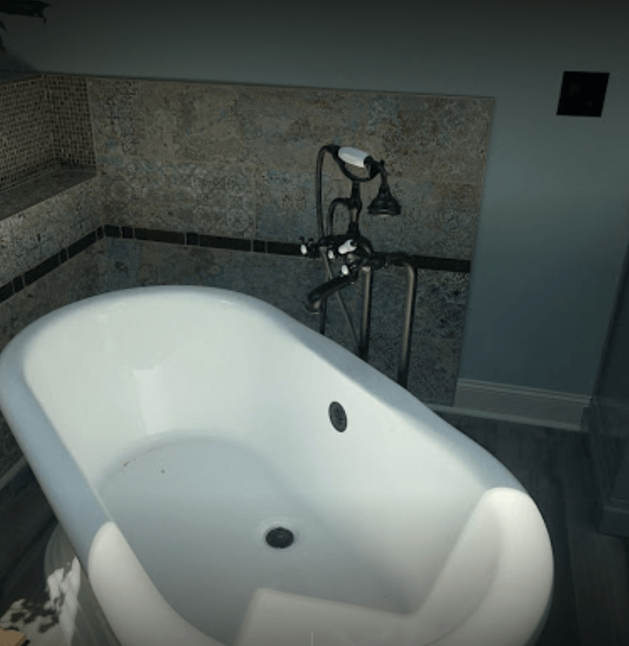 A bathtub in a bathroom with a faucet