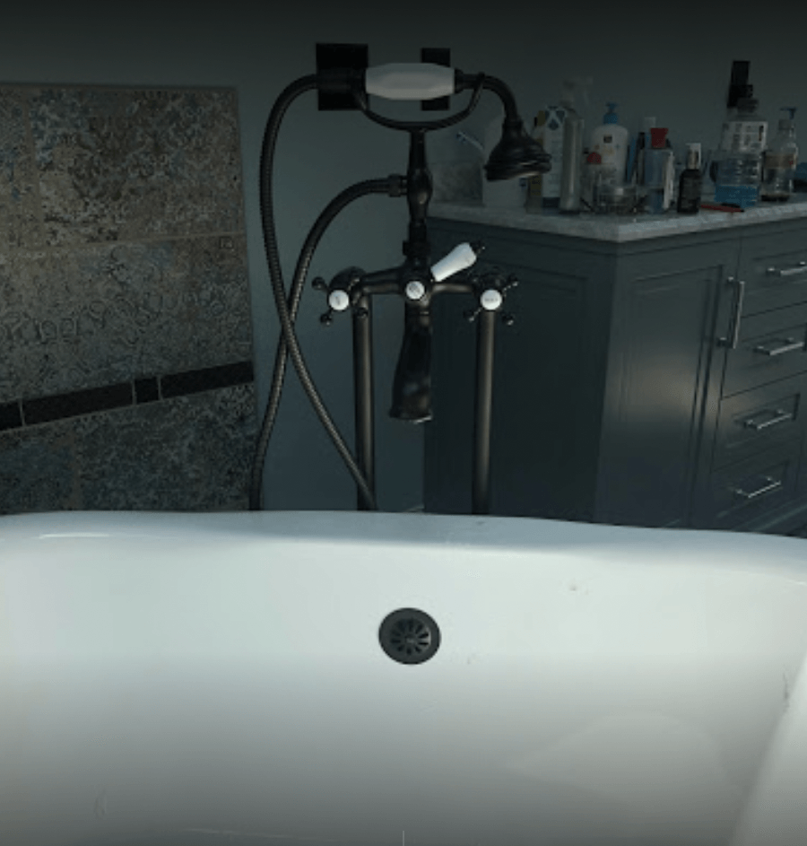 A bathtub in a bathroom with a black faucet