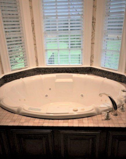 There is a large jacuzzi tub in the middle of the bathroom.