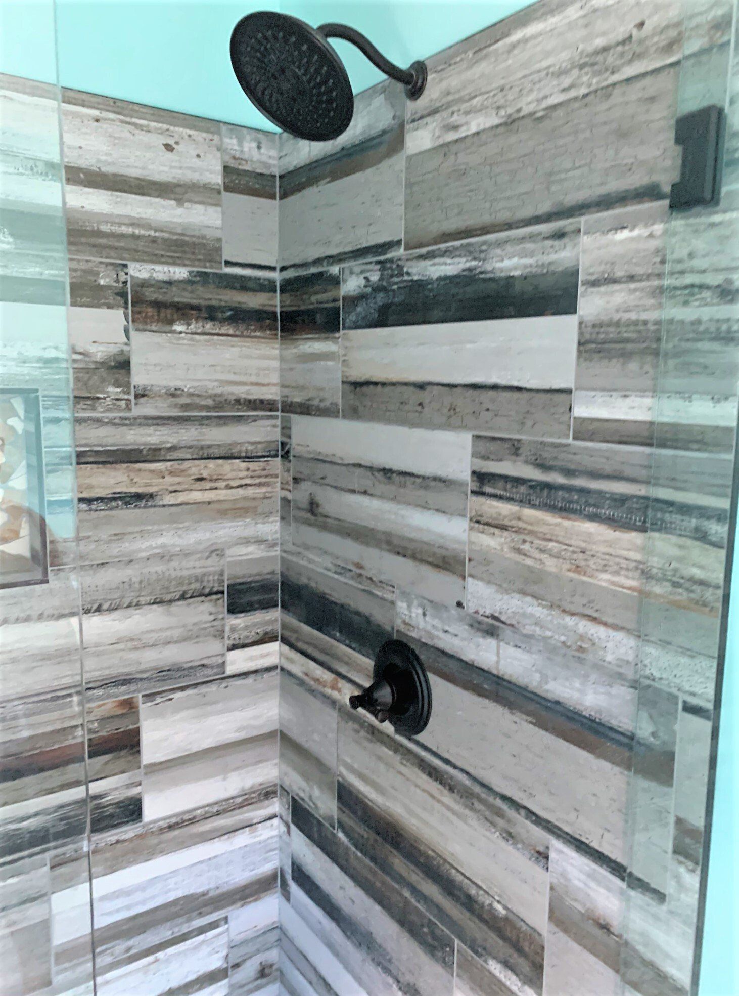 A shower with a shower head and a glass door.