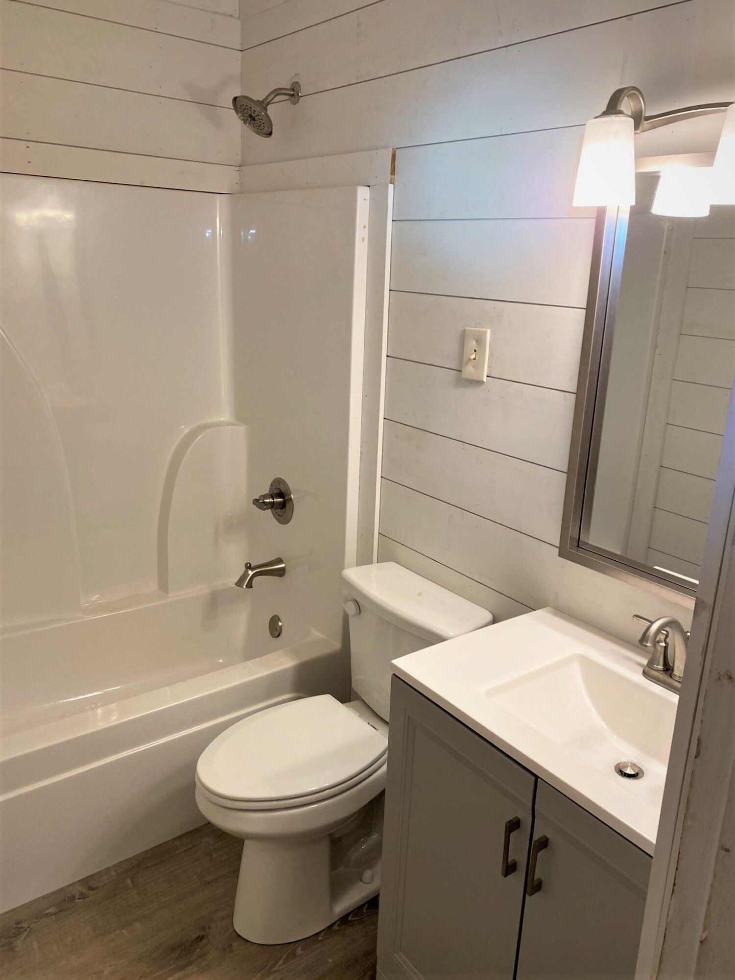 A bathroom with a toilet , sink and bathtub.