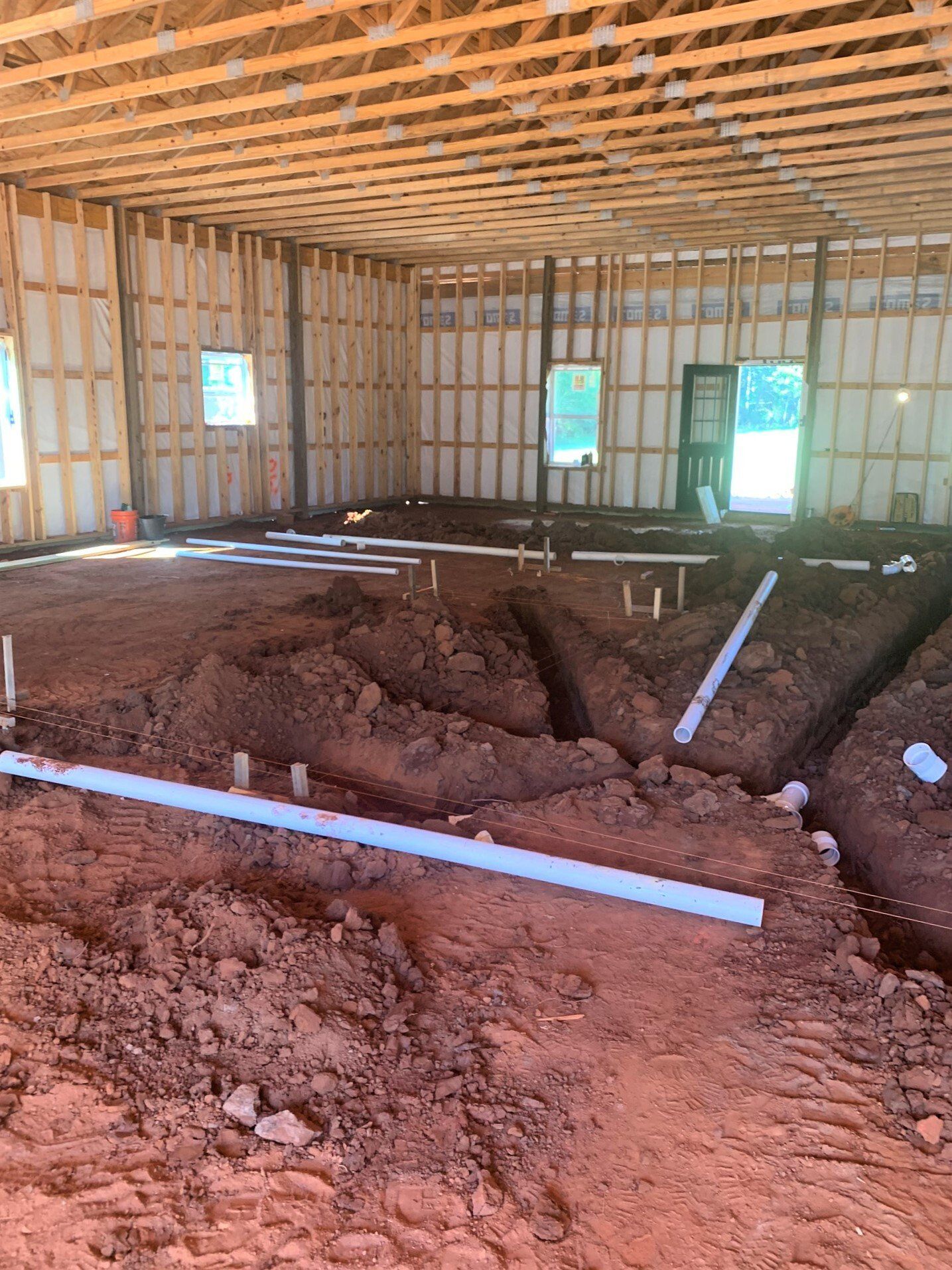 A large room with a lot of dirt and pipes in it.