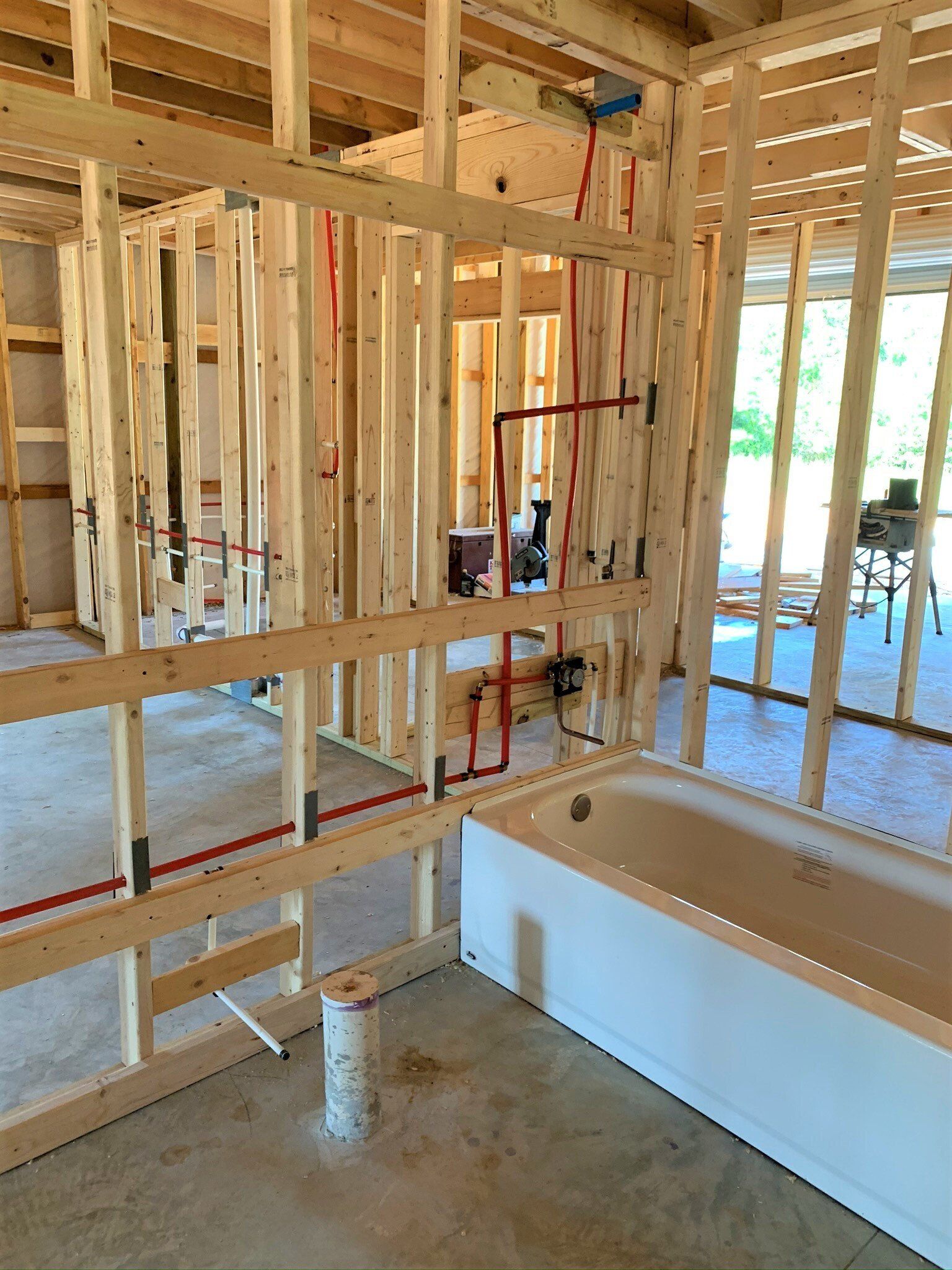A bathroom under construction with a bathtub in the middle of the room.