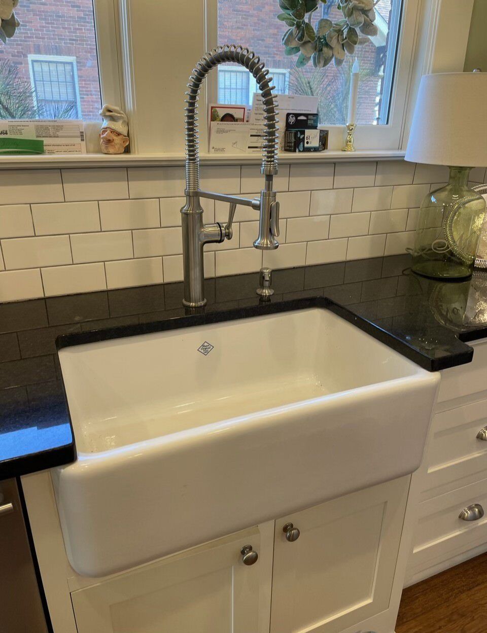 A kitchen sink with a faucet and a window in the background.
