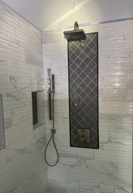 A shower with a shower head and a shower head in a bathroom.