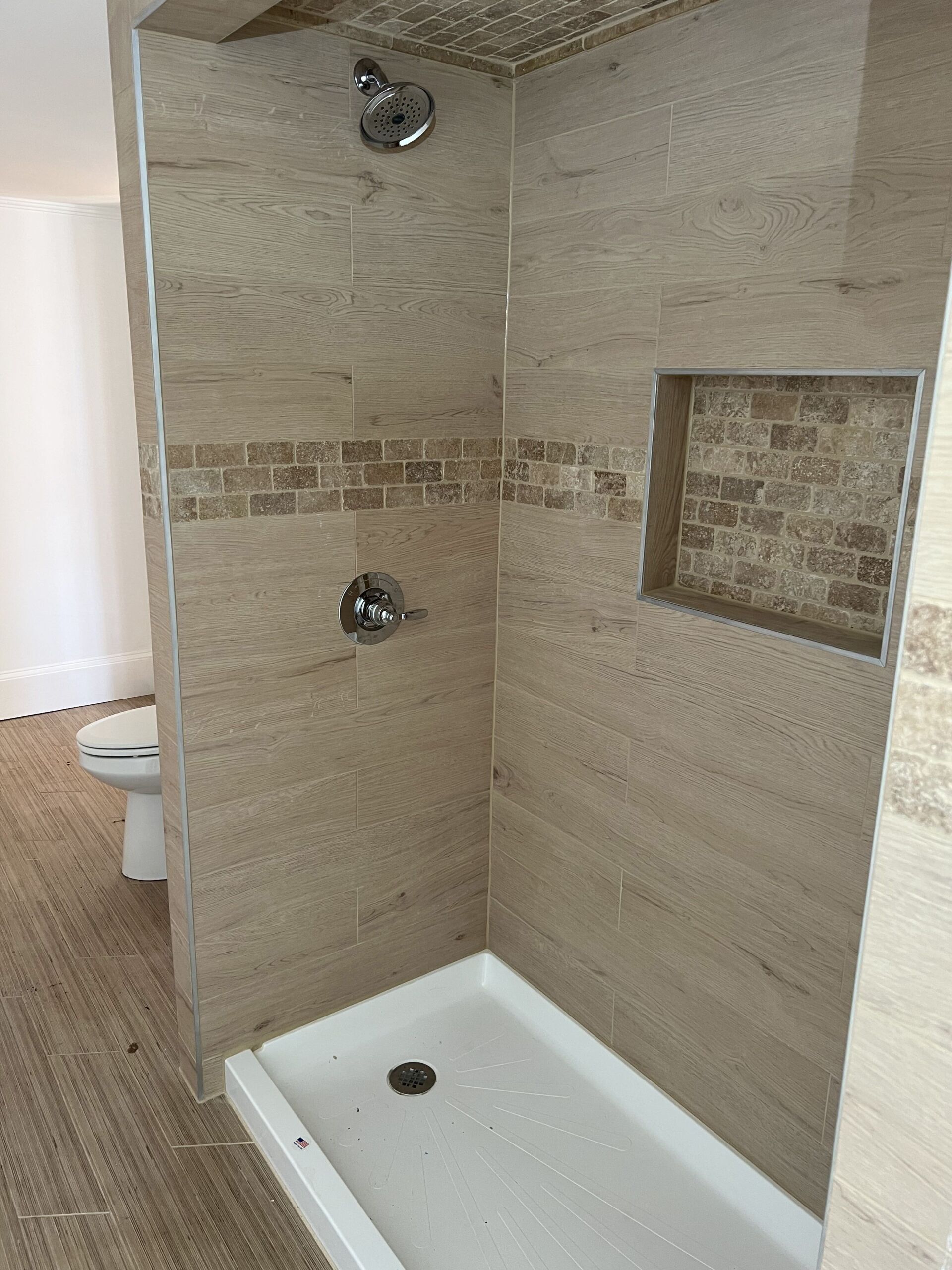 A bathroom with a walk in shower and a toilet.