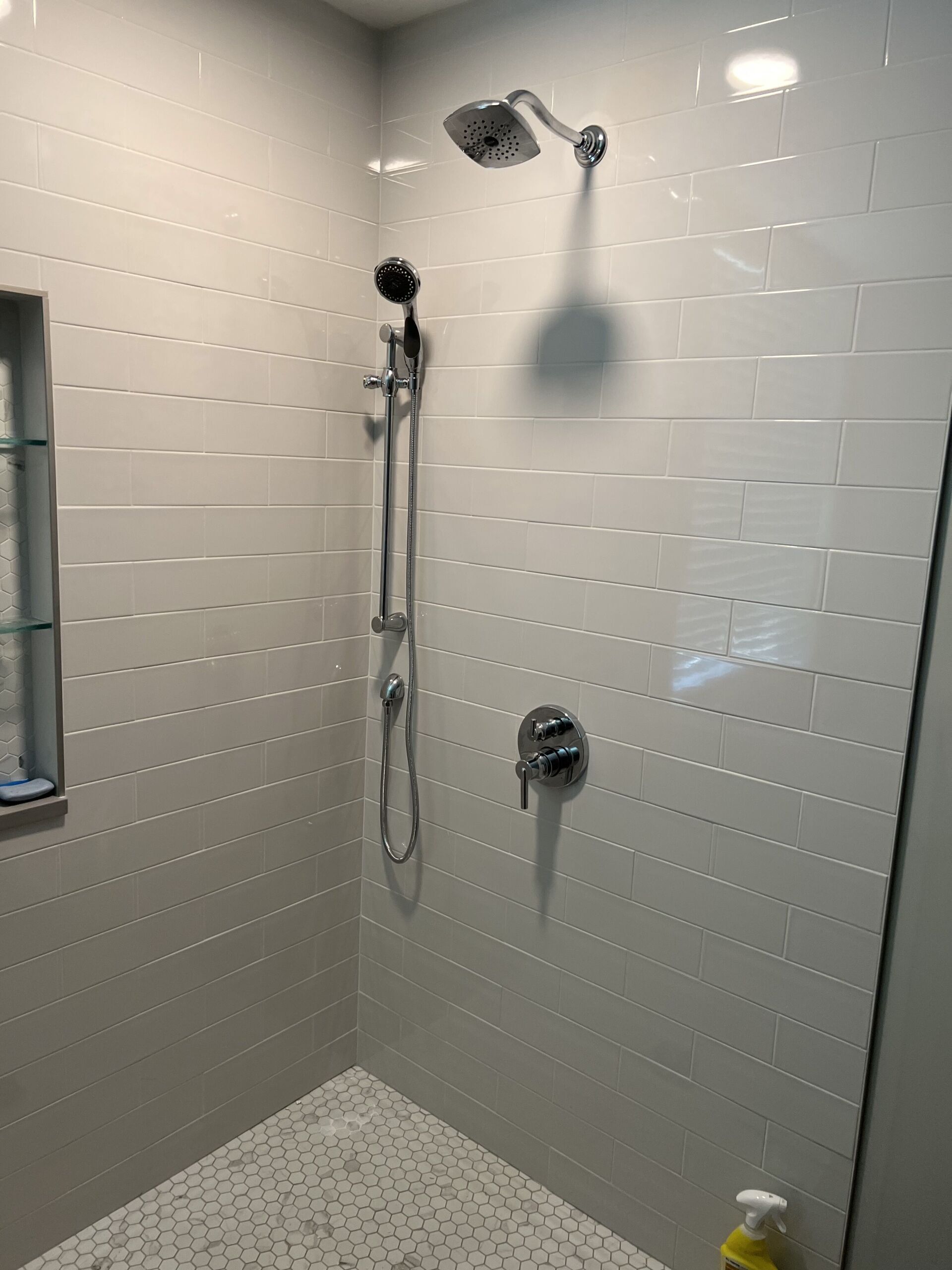 A bathroom with a walk in shower and a shower head.