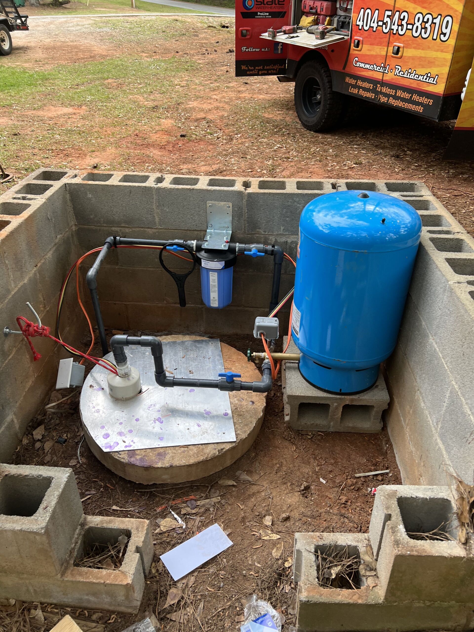 A blue water tank is sitting on top of a concrete block.