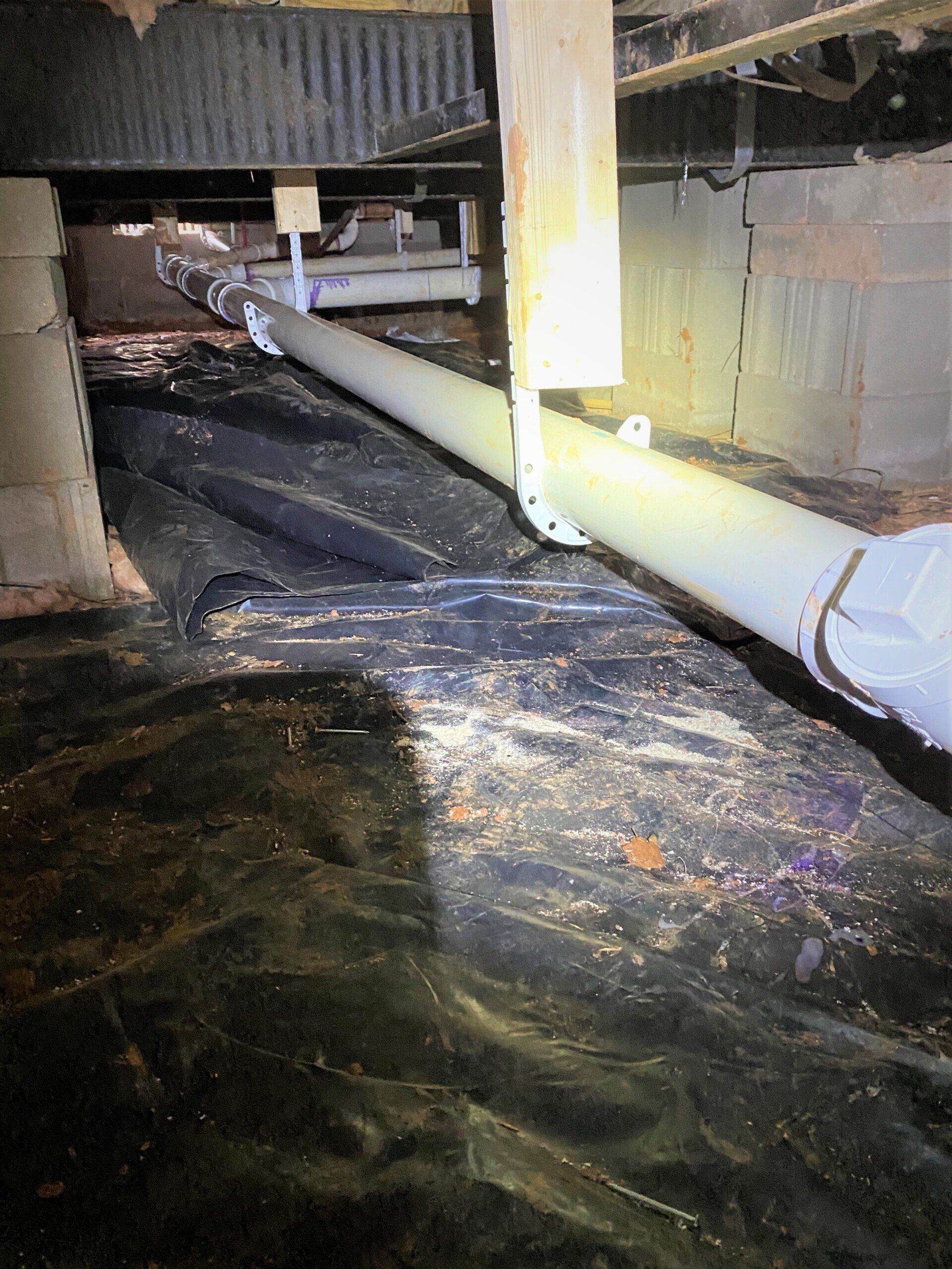 A flooded basement with a lot of pipes coming out of it.