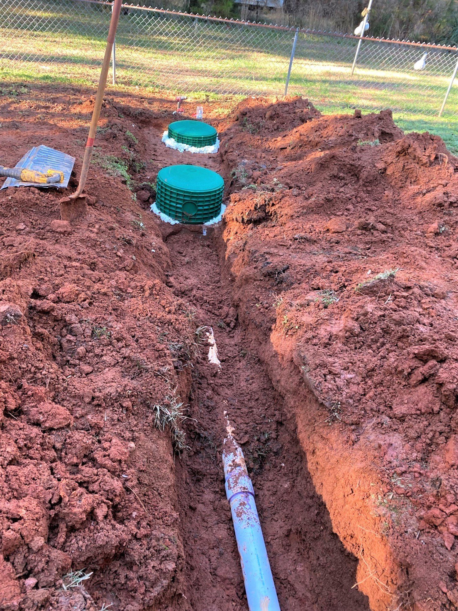 A septic system is being installed in a dirt field.