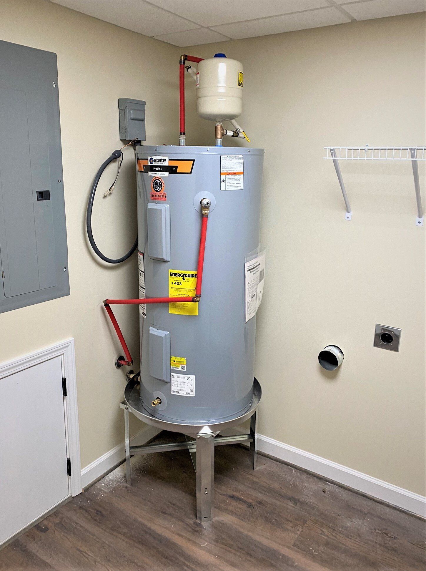 A water heater is sitting in the corner of a room.