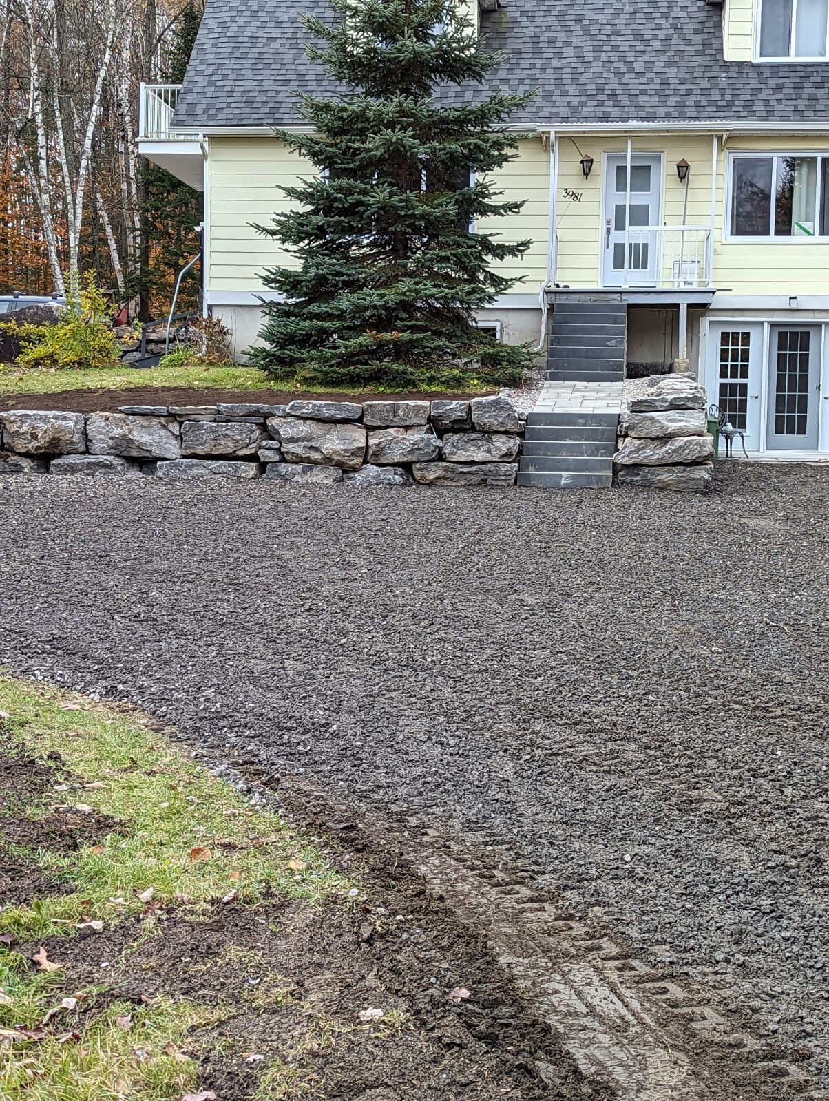 Une maison avec une allée de gravier devant.