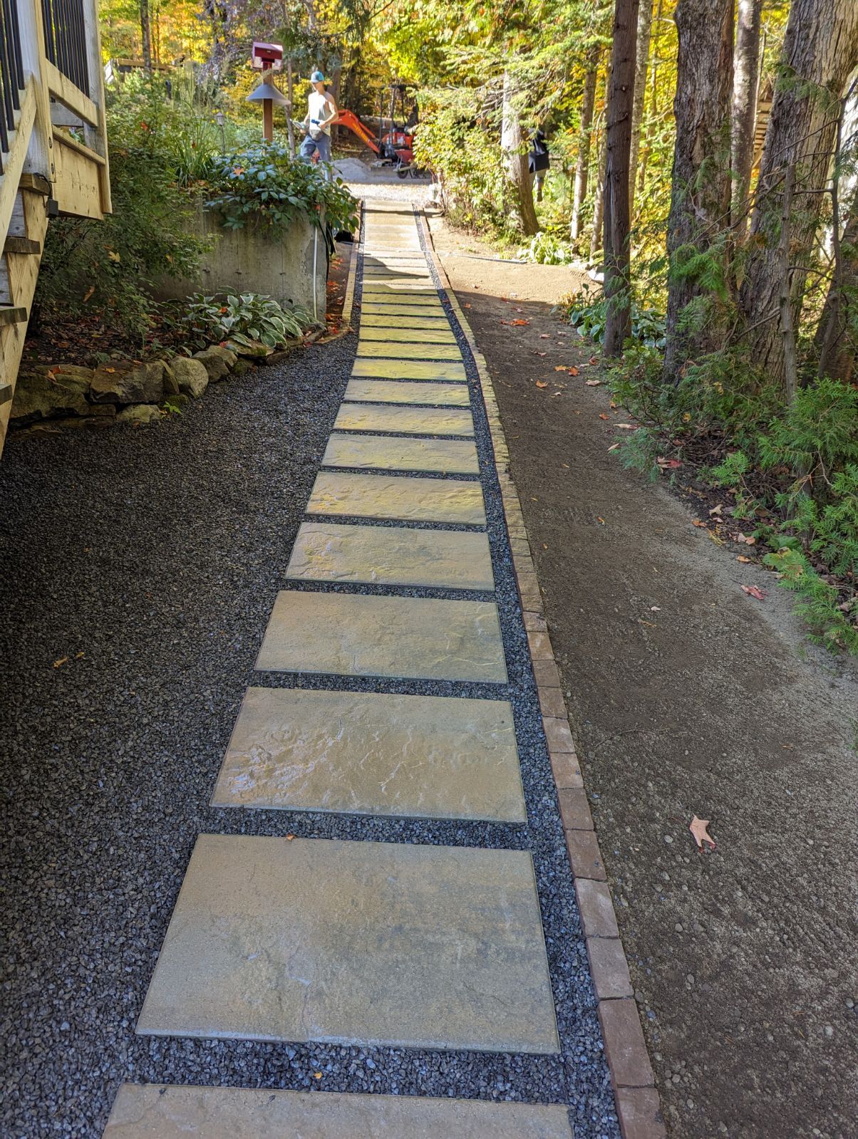 Une passerelle en pierre menant à une maison dans les bois.
