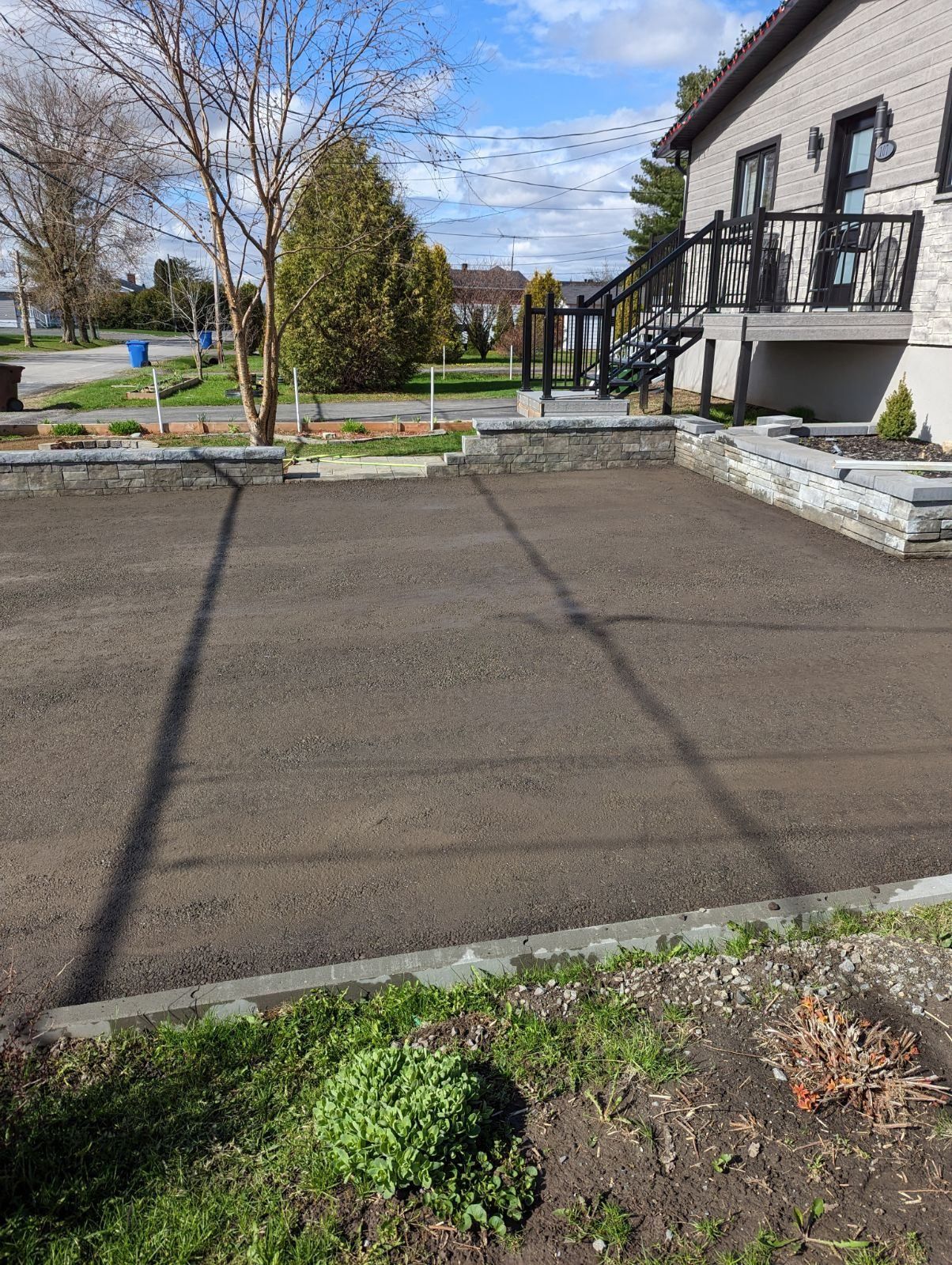 Une maison avec une allée en béton devant.