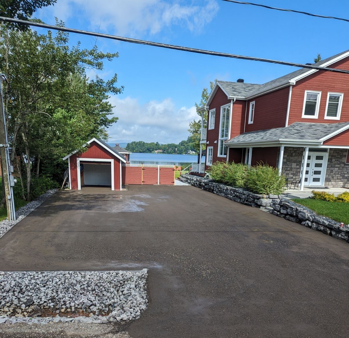 Une maison rouge avec un garage à côté